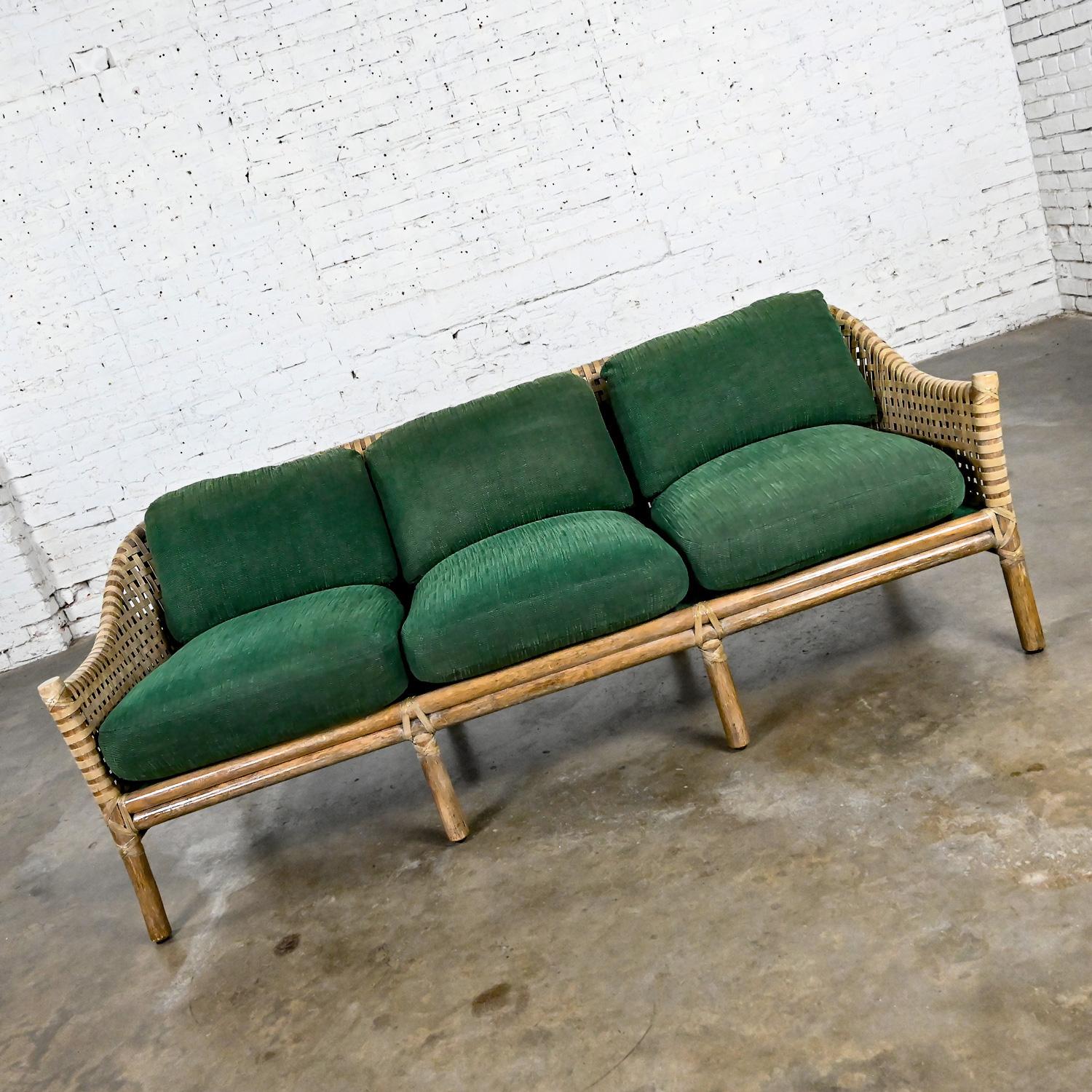Wonderful vintage modern rattan & woven rawhide sofa or settee with loose green chenille cushions by McGuire. Beautiful condition, keeping in mind that this is vintage and not new so will have signs of use and wear even if it has been refinished or