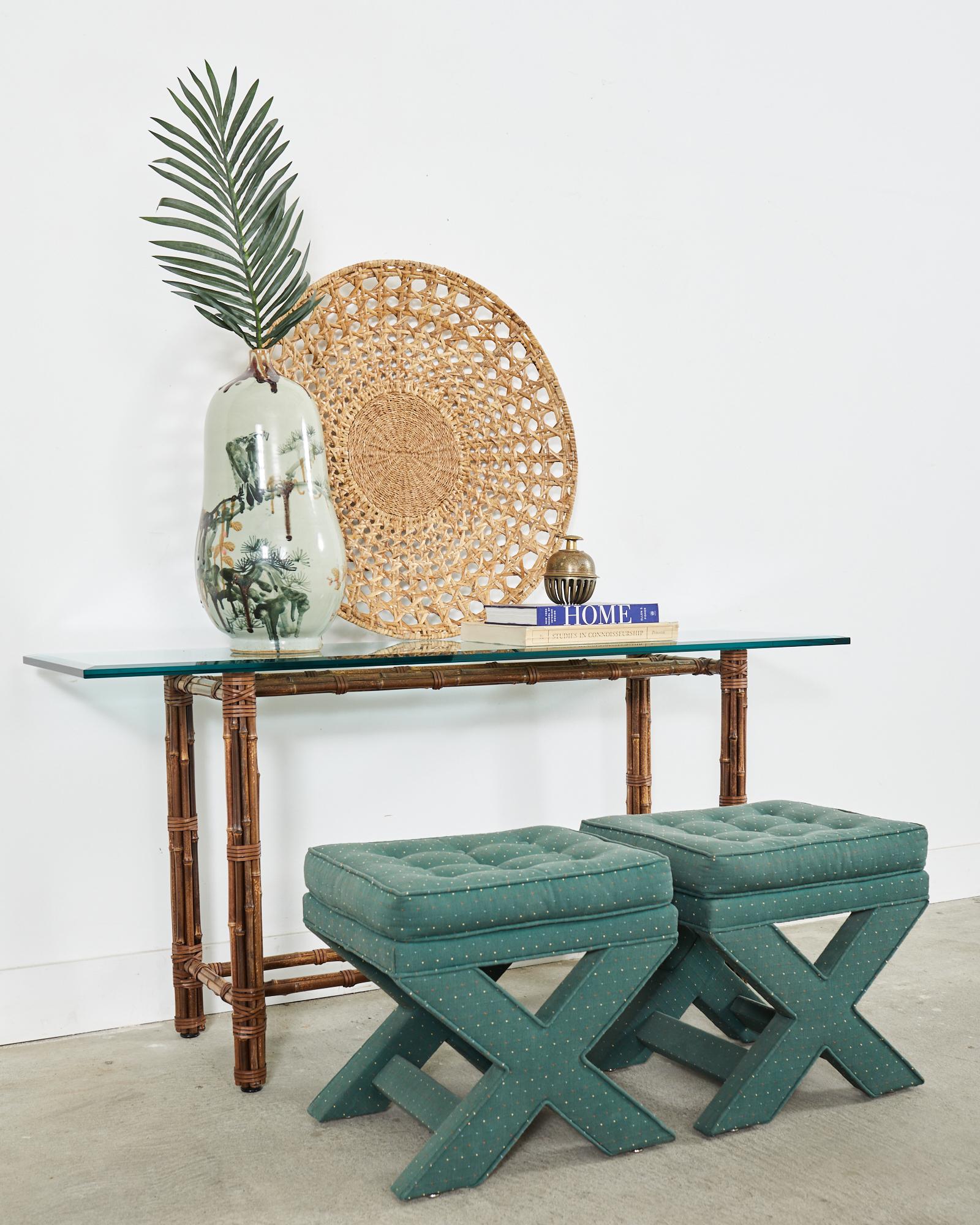 Distinctive console or sofa table made in the California coastal organic modern style by McGuire. The table features an iron frame painted golden gate orange for authenticity and wrapped with bamboo poles lashed together with leather rawhide laces.