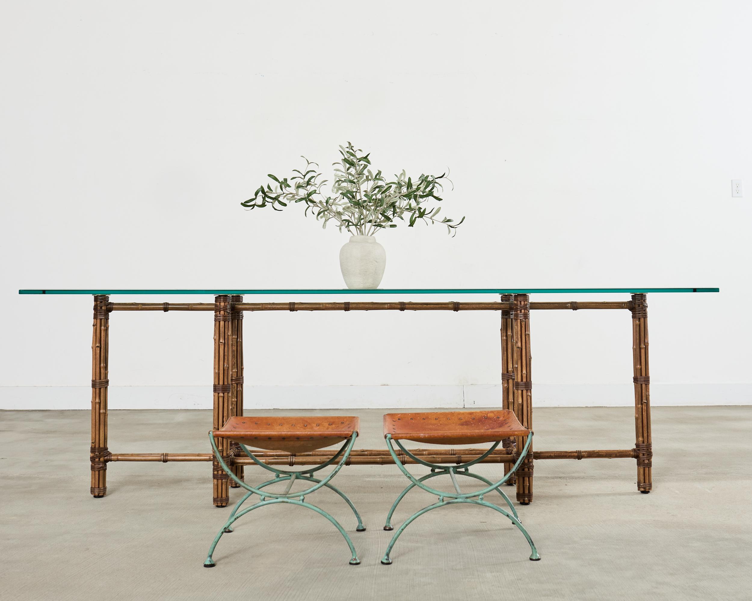 Monumental bespoke bamboo console table measuring 8 feet long. The genuine table is made by McGuire and is not an inferior reproduction piece. It features an iron base painted golden gate orange for autnenticity and covered with bamboo poles lashed