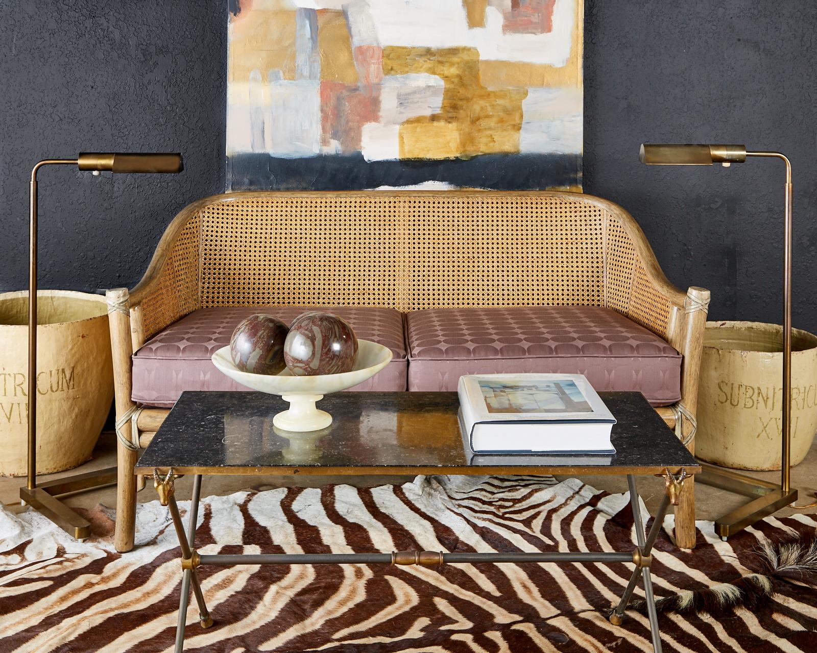 Genuine McGuire settee made in the California organic modern style. Features a bamboo rattan pole frame with double caned sides. The exposed joints are lashed together with leather rawhide strapping. Reupholstered with a Mid-Century Modern fabric