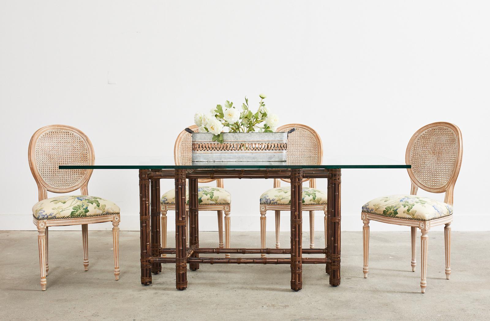 Handsome bamboo rattan rectangular dining table made in the California organic modern style by McGuire. Genuine McGuire model #MCBA22 with an iron frame painted golden gate orange for authenticity. The eight leg base measures 46 wide by 21 inches
