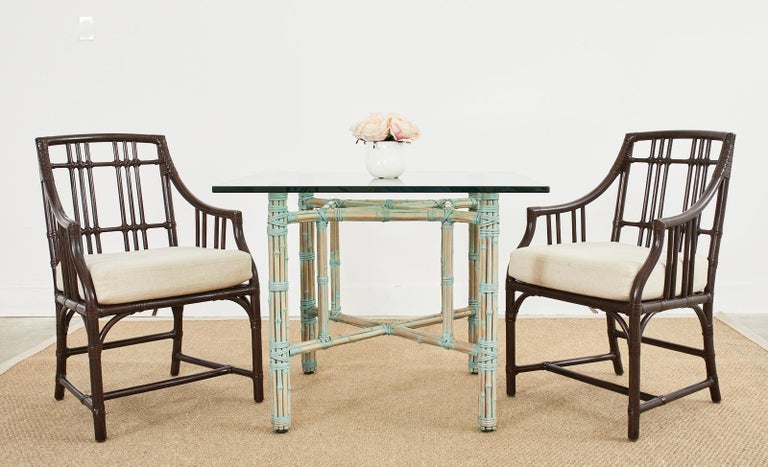 Genuine McGuire bamboo rattan dining table made in the California organic modern style. The table features a rare, bespoke glazed finish with a green verdigris patina tone. Crafted from an iron frame painted golden gate orange for authenticity and