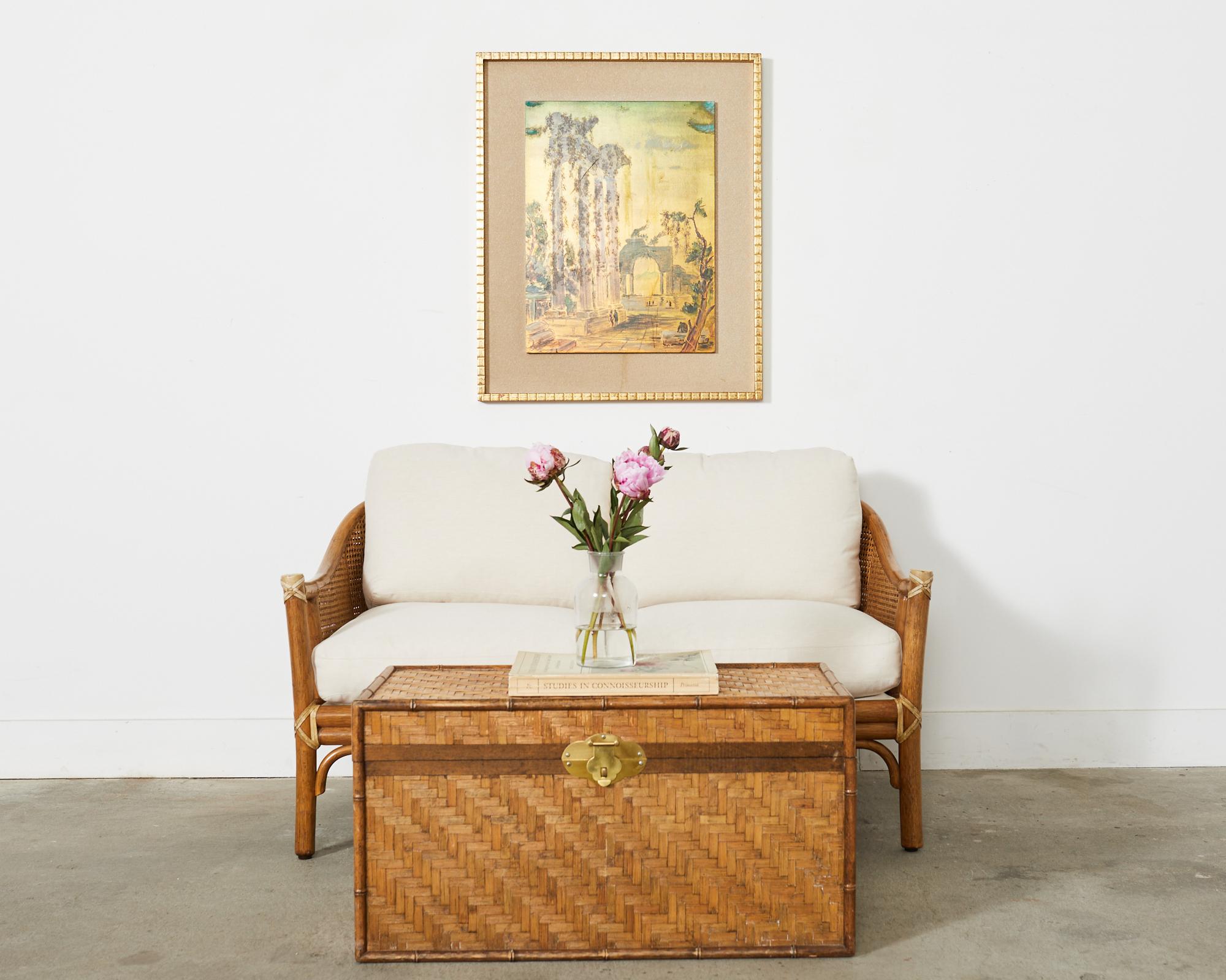 Genuine McGuire sofa settee or loveseat made in the California coastal organic modern style by McGuire. The settee features a thick rattan pole frame with double caned sides and back. The exposed joints are lashed together with leather rawhide laces