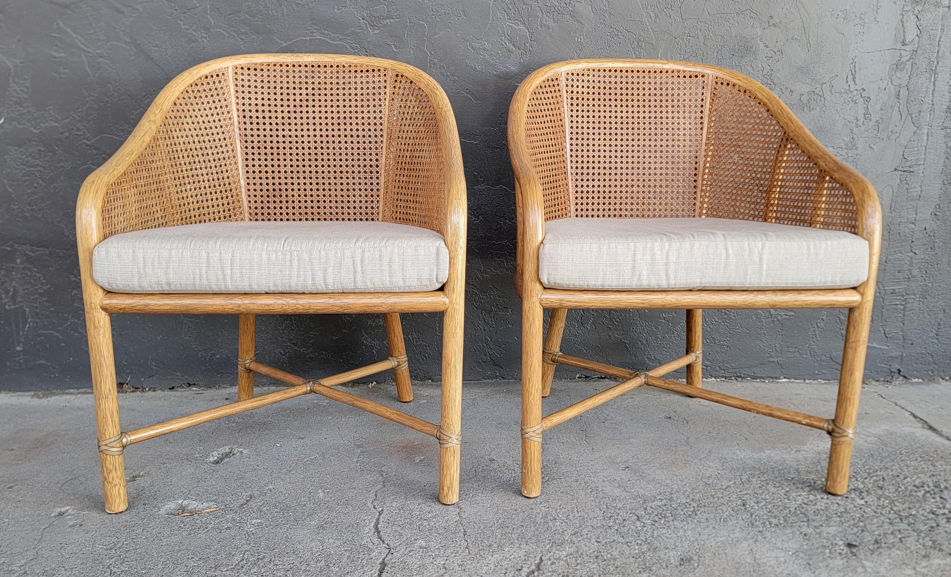 A pair of organic modern lounge chairs by McGuire. Rattan frames with woven cane and reversible cushions. Very good original condition. Sturdy.

24.25 inches wide.
31.25 inches high.
22 inches deep.
Seat Height 18.75 inches.