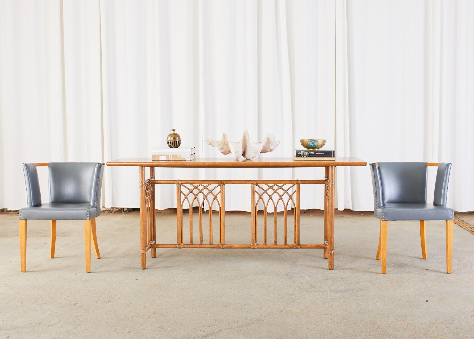 Distinctive oak and rattan sofa or console table made by McGuire in the California organic modern style. The long table features an oak top bordered with a rattan bull nose edge. The trestle style base has four windows decorated with rattan poles