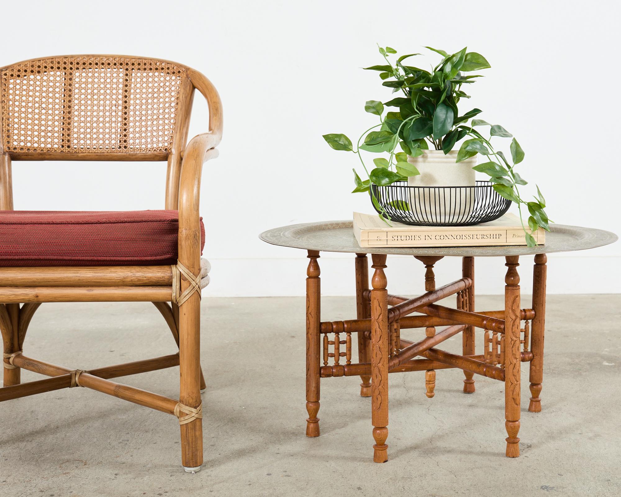 A sinuous rattan framed armchair featuring a woven honeycomb cane back crafted in the California coastal organic modern style by McGuire. The chair has a gracefully curved pole rattan back that becomes the arms and front legs. The rattan is