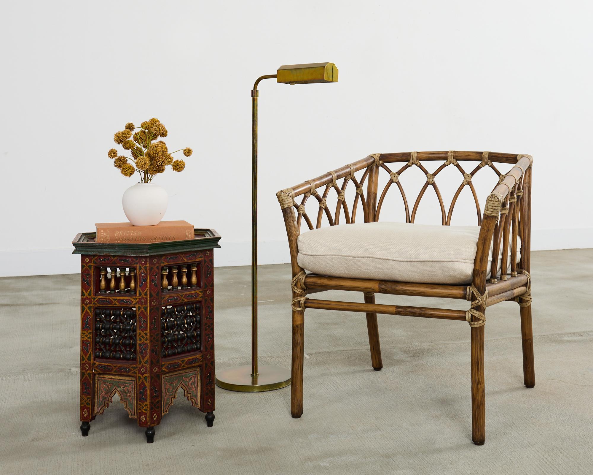 Gorgeous square box form rattan armchair made in the California coastal organic modern style by McGuire artisans. The rare chair features a pole rattan and oak frame having decorative open fretwork cathedral design on the back and sides. The rattan