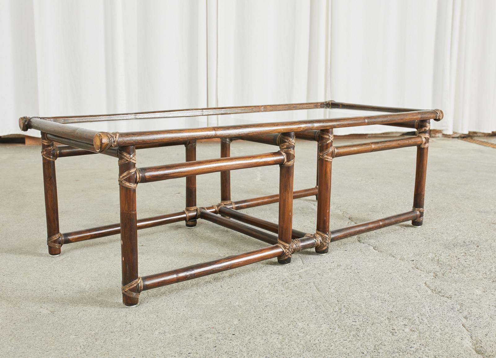 Genuine McGuire rattan coffee table or cocktail table with an inset pane of glass on top. Made in the California organic modern style featuring rattan poles lashed together with leather rawhide laces and caps. The open fretwork design keeps the
