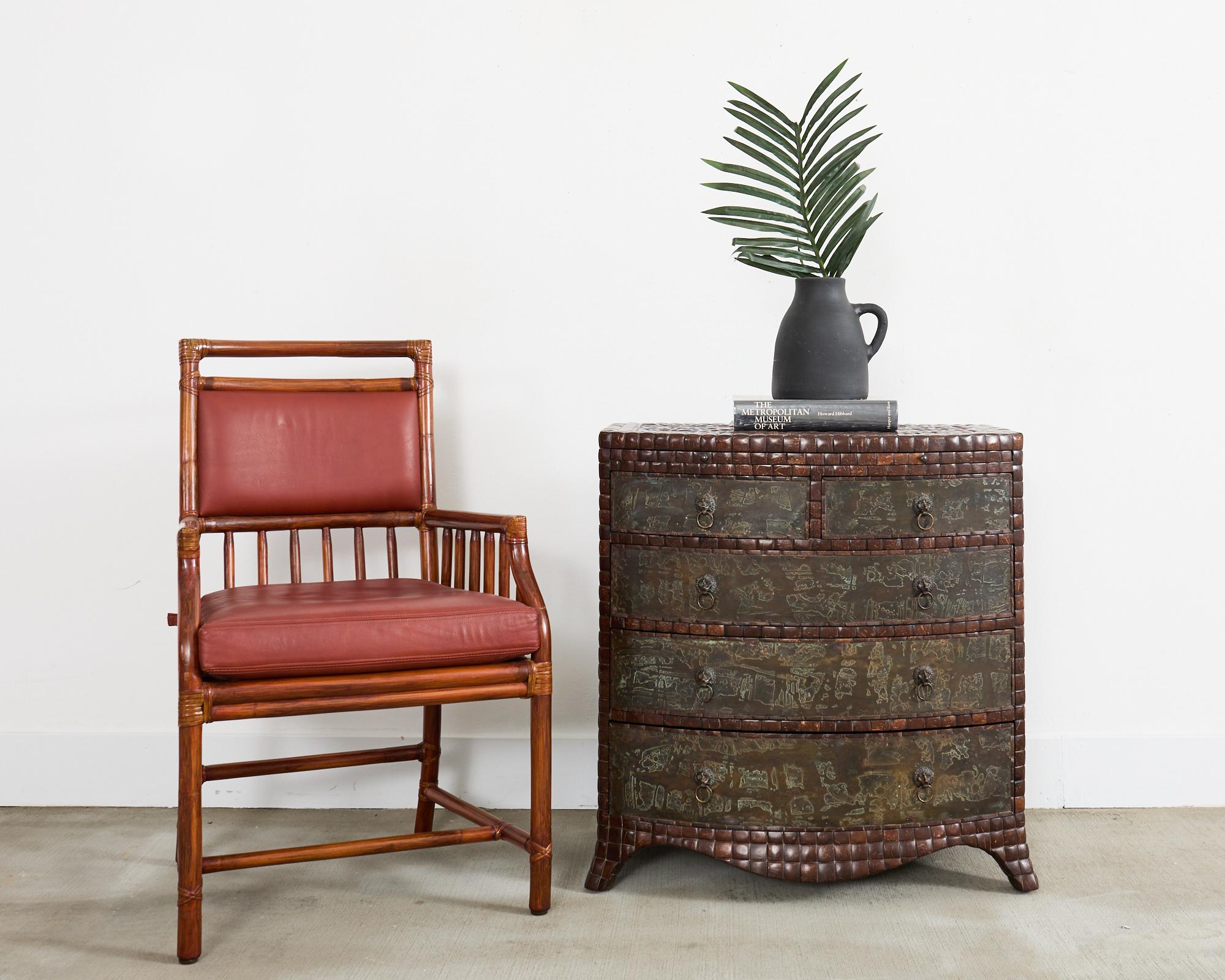 Precioso sillón de biblioteca McGuire de estilo moderno orgánico. El sillón presenta una construcción de ratán de palo con cordones de cuero crudo con un rico acabado teñido oscuro. El generoso asiento está provisto de un cojín de piel en un