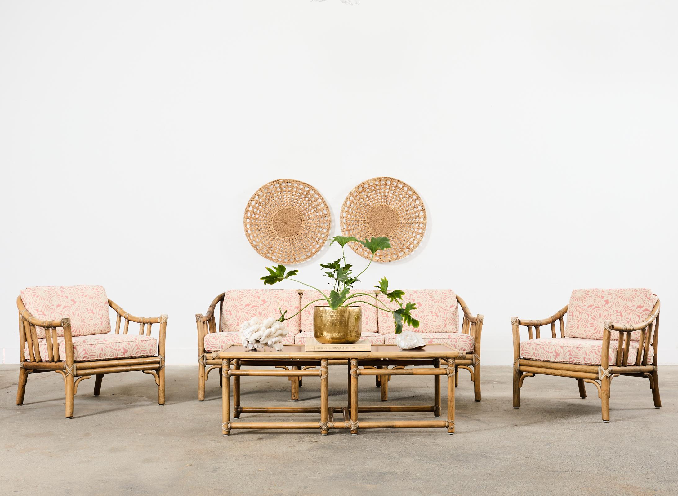 Stylish matching rattan living room suite consisting of a settee, two lounge chairs, and a coffee table made by McGuire artisans in the California coastal organic modern style. The set features thick, bent pole rattan frames with gracefully curved