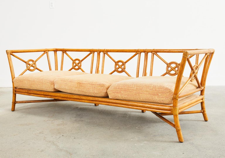 Genuine McGuire rattan sofa or daybed made in the California organic modern style. The sofa features a target motif design back and sides designed by Elinor McGuire. Constructed with thick rattan poles the frame has a beautifully waisted form that
