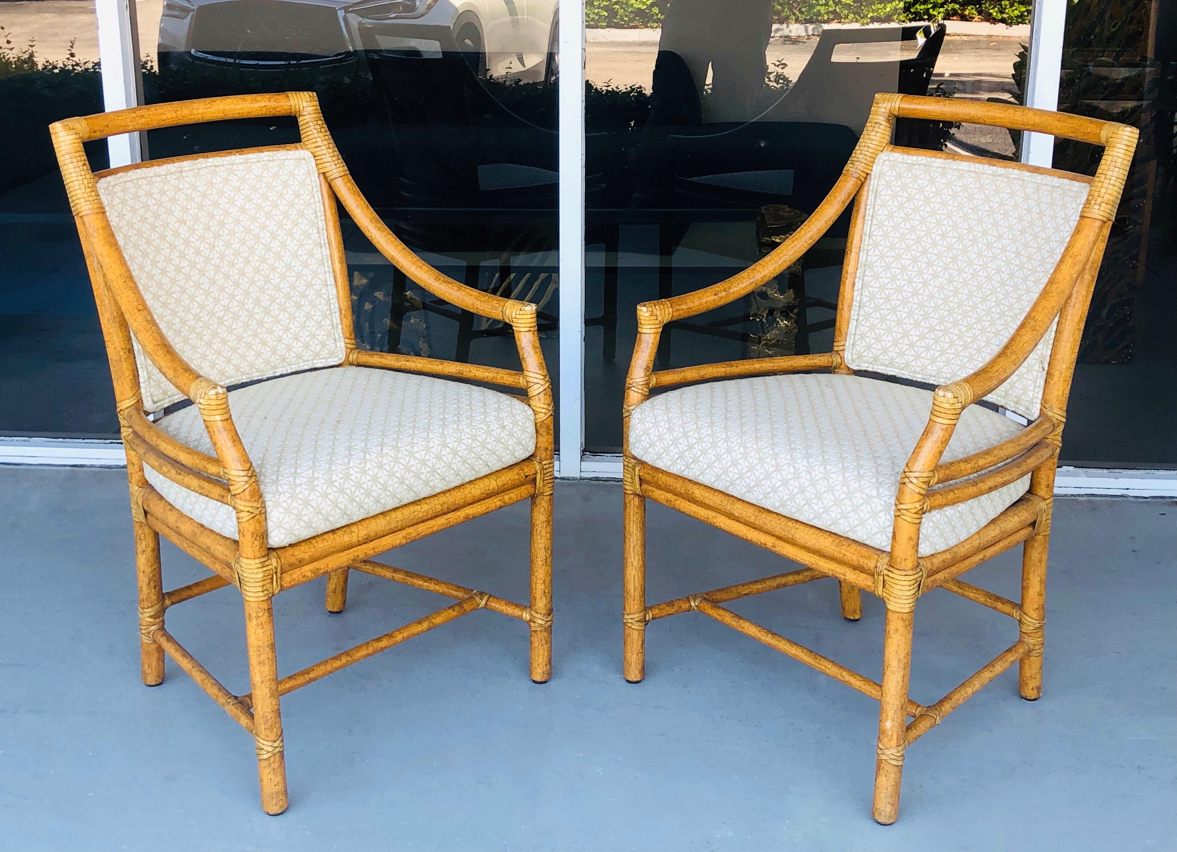 A pair of McGuire Rattan arm chairs. 3 pairs available. Note the beautiful custom finish and embroider upholstery.