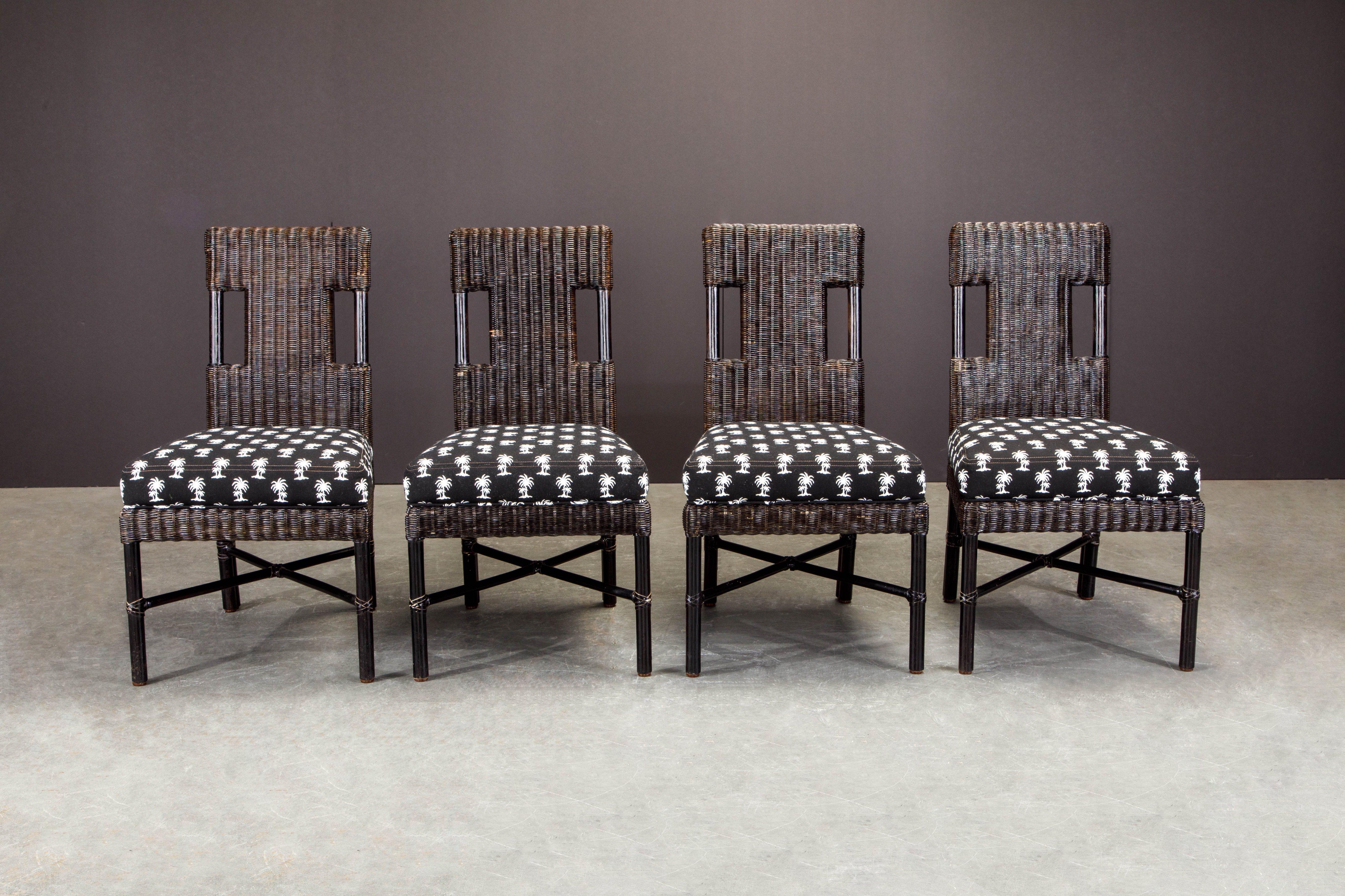 An elegant set of four (4) wicker McGuire cafe chairs (signed) that can be used indoor or out. Fabricated from woven wicker that has been finished in a black color with palm tree decorated fabric seats giving a tropical touch. Under the seat the