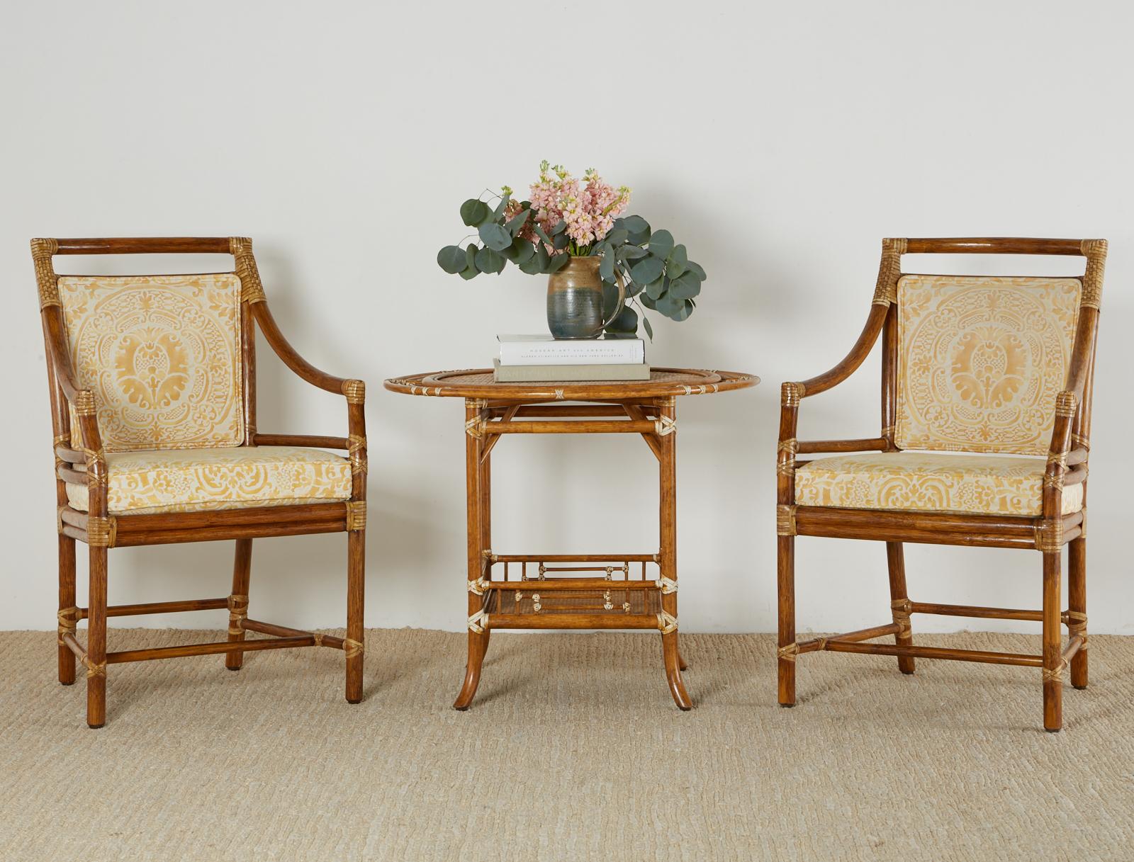 Attractive genuine McGuire occasional table or centre table featuring a round target style top. Constructed from rattan poles lashed together with leather rawhide laces in a lovely cream color. The top has decorative bamboo rings with a grasscloth