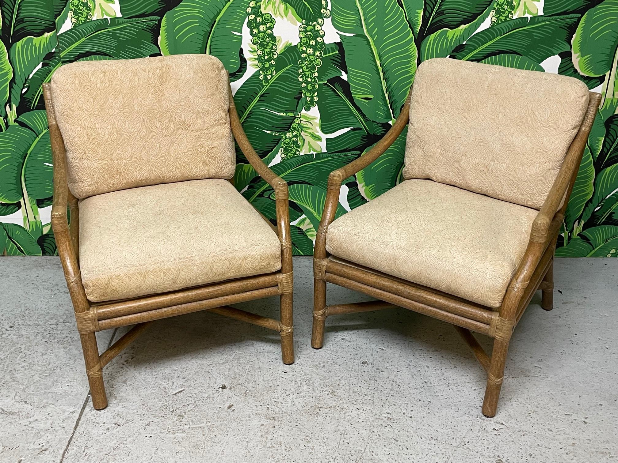 Pair of rattan arm chairs by McGuire feature the iconic target back design with an ebony ring to accent the center. Heavy rattan poles lashed with rawhide leather laces. A ?perfect patina to the finish and large comfortable cushions.Very solid