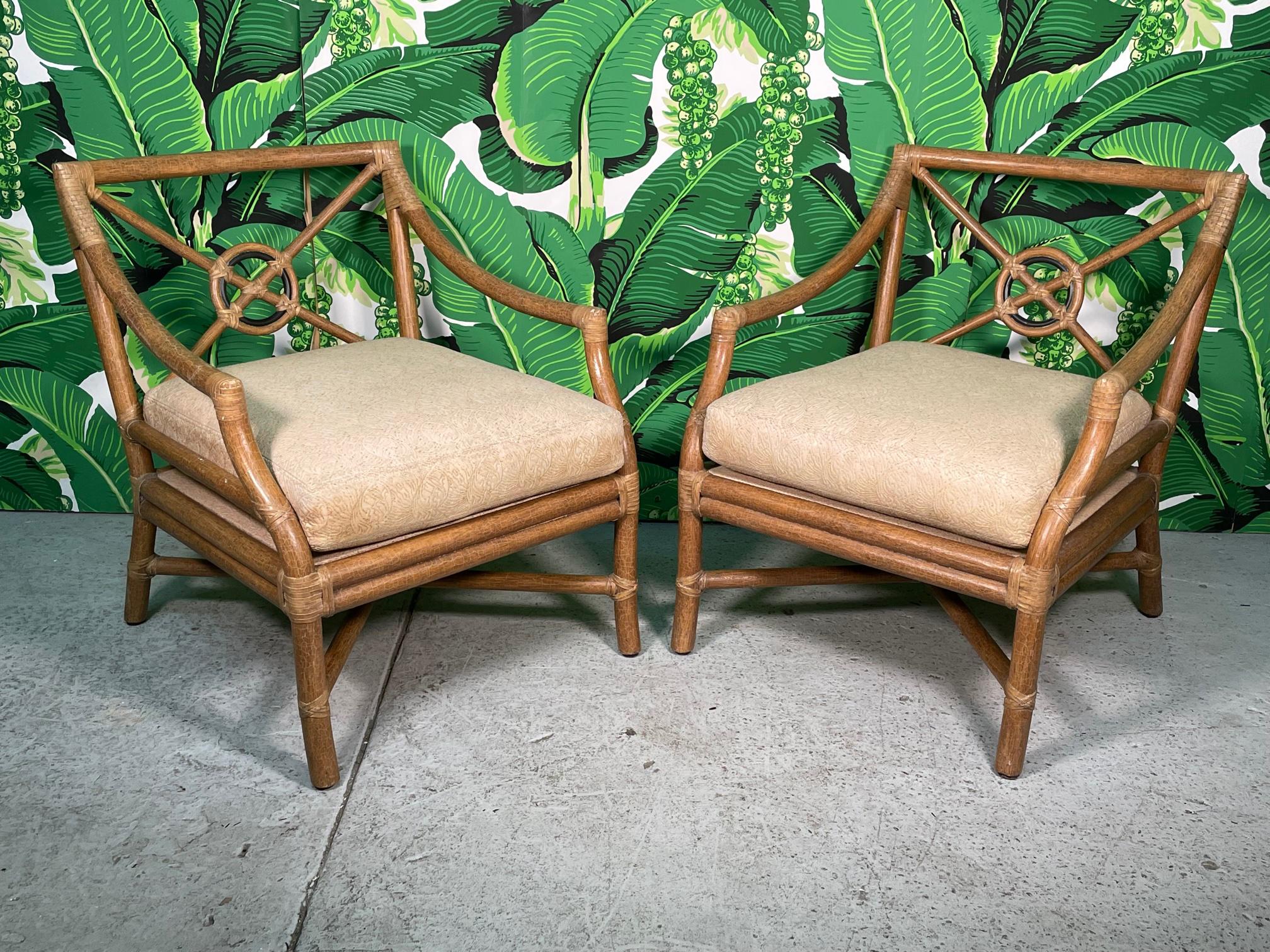 Pair of rattan arm chairs by McGuire feature the iconic target back design with an ebony ring to accent the center. Heavy rattan poles lashed with rawhide leather laces. A perfect patina to the finish and large comfortable cushions. Very solid
