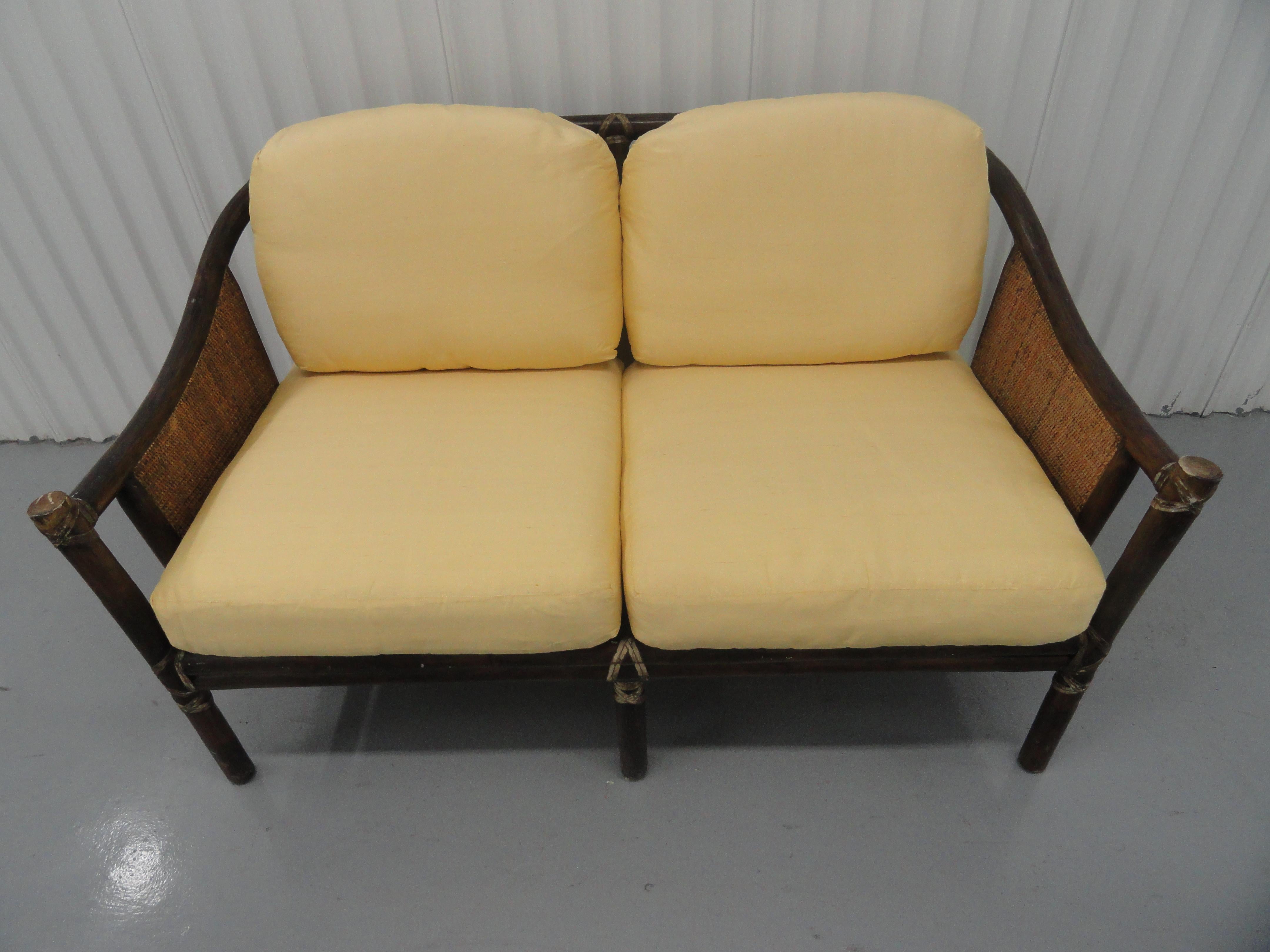 Classic McGuire settee with new strapping and newer upholstered cushions in silk.