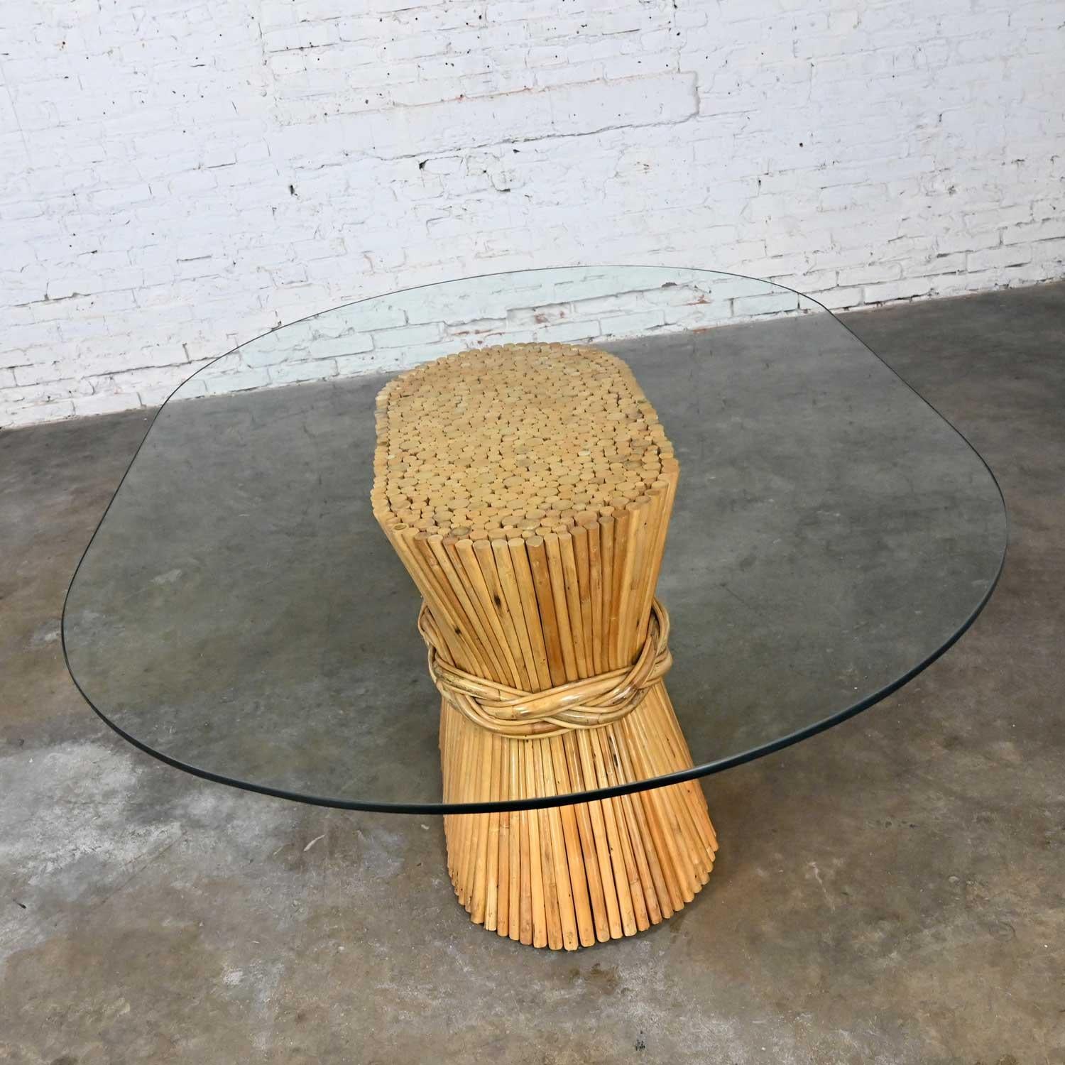 Stunning vintage racetrack oval shaped natural rattan sheaf of wheat dining table with racetrack oval glass top in the style of McGuire. Beautiful condition, keeping in mind that this is vintage and not new so will have signs of use and wear. Please