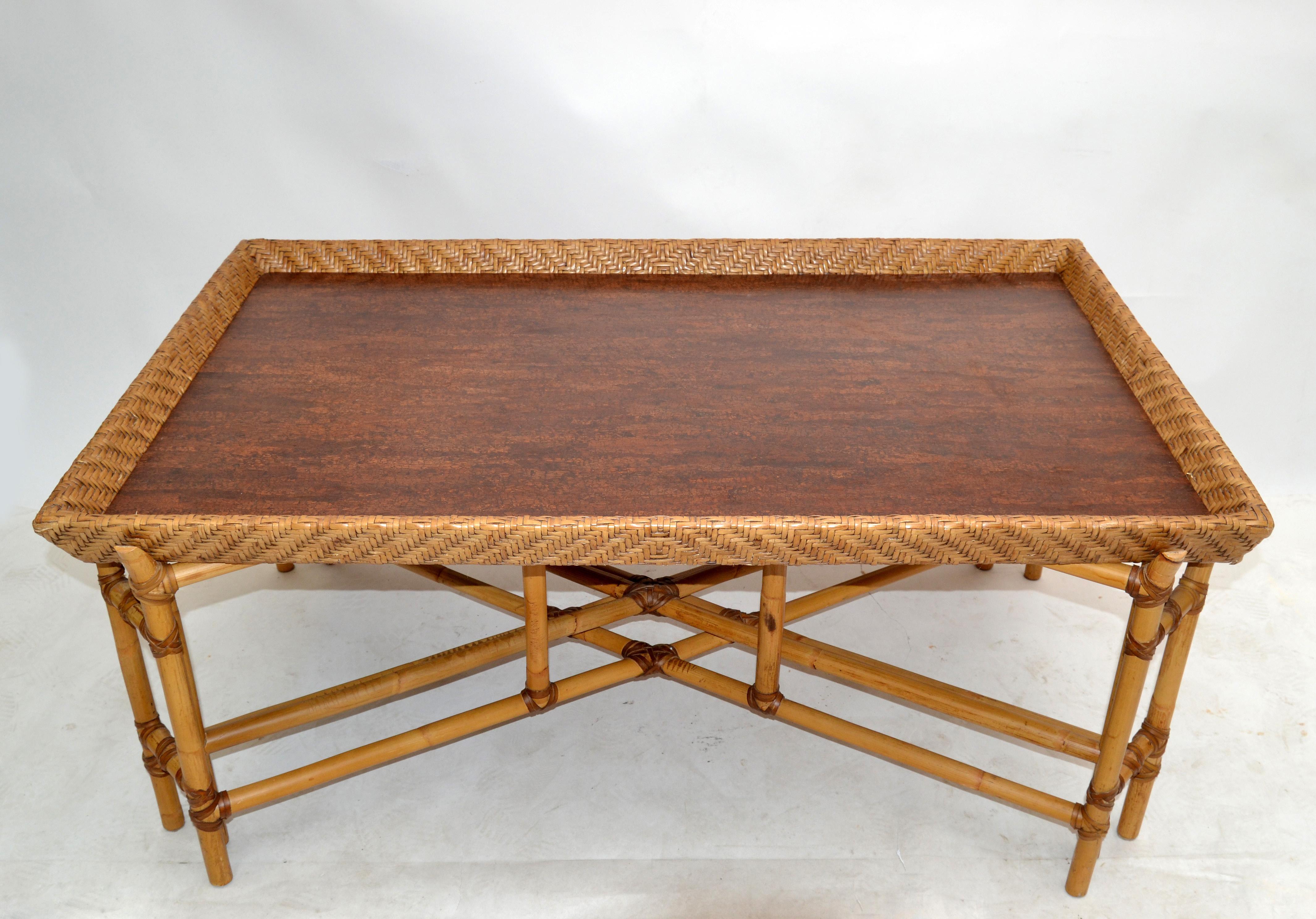 McGuire style traditional tray coffee table Mid-Century Modern in light bamboo, woven with Leather bindings around the joints.
The top is a handmade tray woven with cane and bamboo boards and sits perfect in the four corners.
Impressive, durable