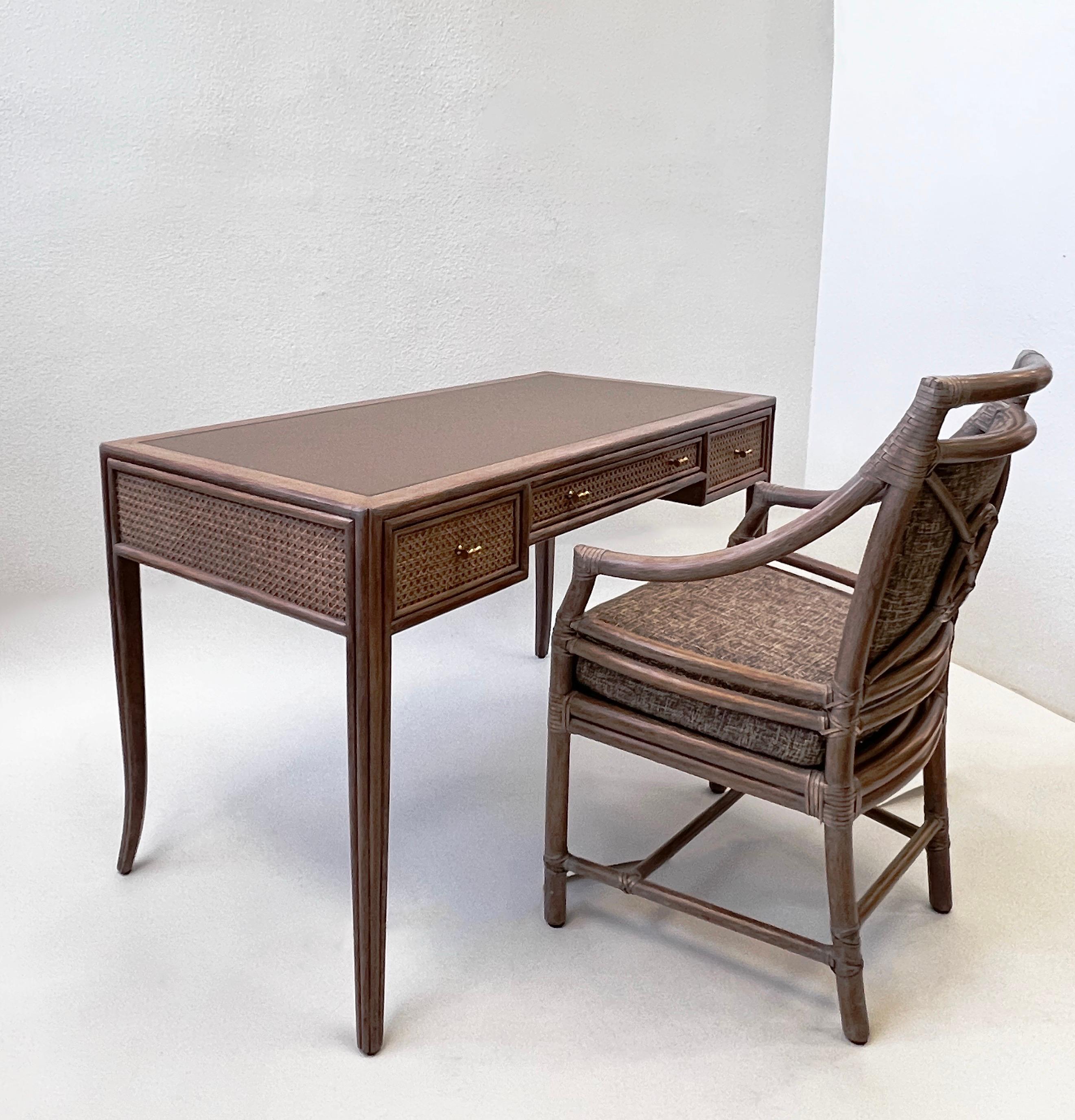 Bellissima scrivania e sedia McGuire degli anni '70, disegnata da Elinor McGuire. 
La scrivania è in rovere massiccio imbiancato, con piano in pelle e tiranti in bambù in ottone.
Ha tre cassetti. 
La sedia è in bambù con cinghie di cuoio, appena