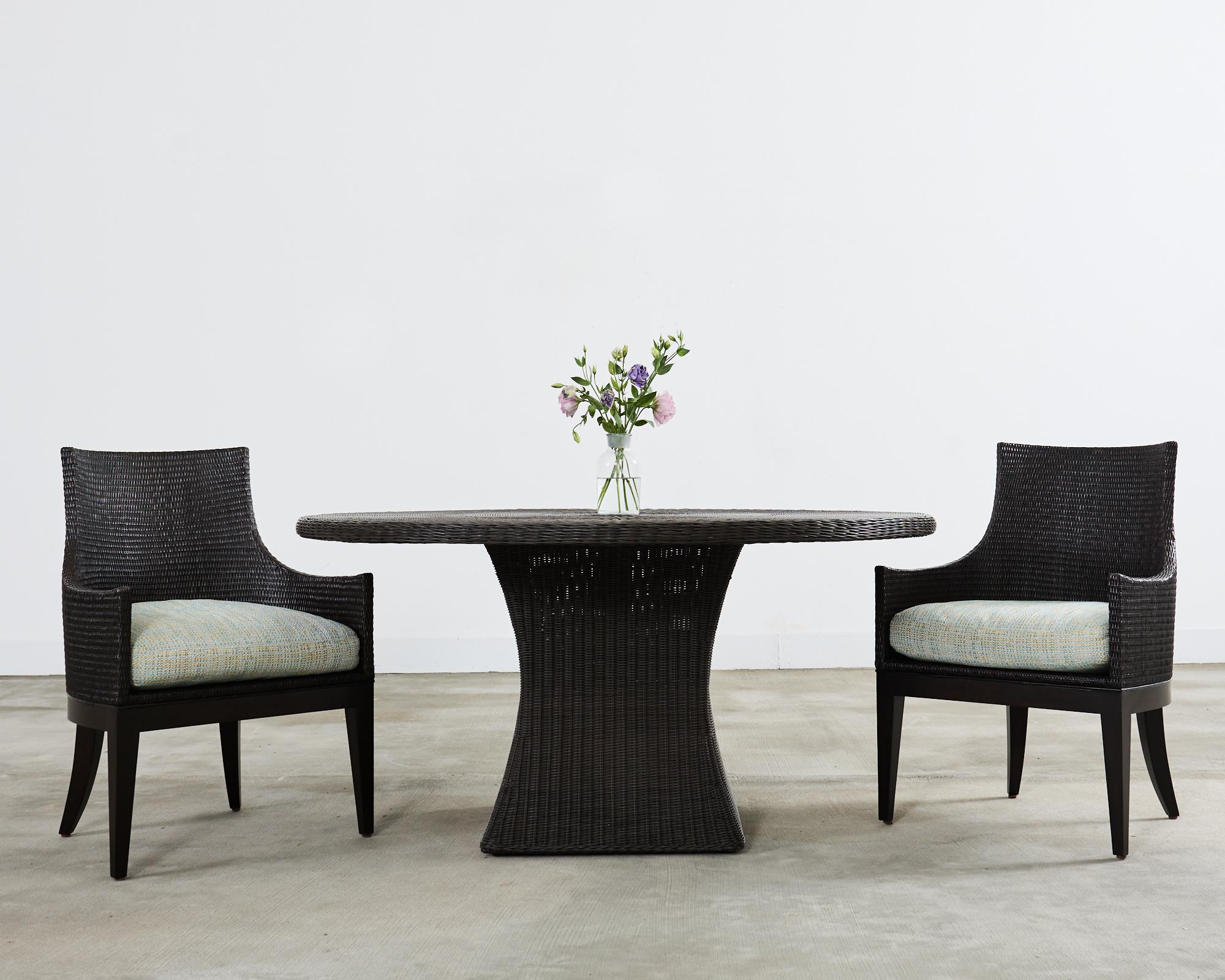 Superbe table de patio et de jardin en résine tressée, conçue par Thomas Pheasant pour McGuire. La grande table ronde a un plateau de 1,5 pouce d'épaisseur soutenu par une base carrée avec une forme subtile de verre d'heure. La table est dotée d'une