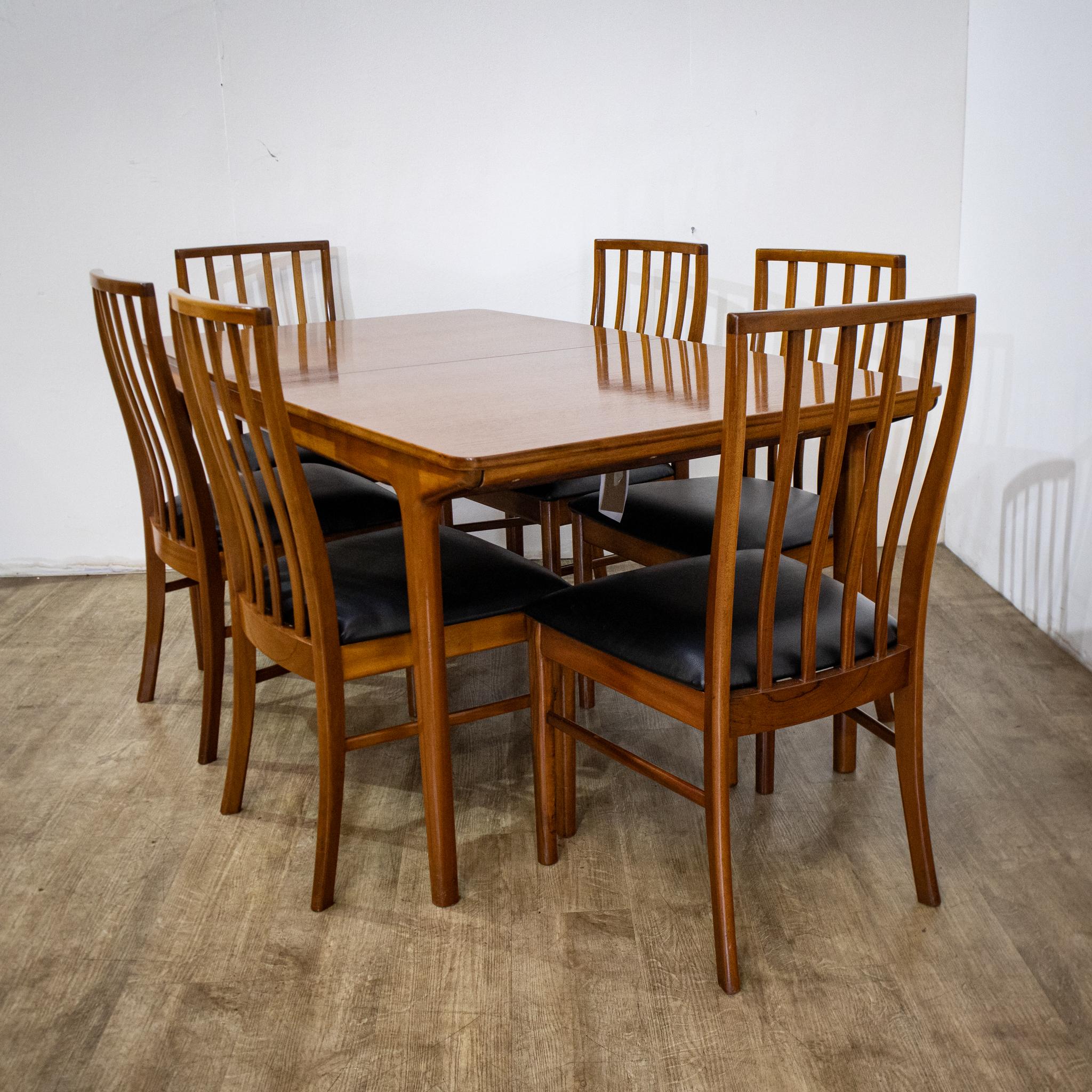 Stylish McIntosh extending dining table and matching set of 6 dining chairs with upholstered seats. Displaying timeless rich colours of the natural teak and classic mid-century modern dining chairs boasting an elegant form and black seat