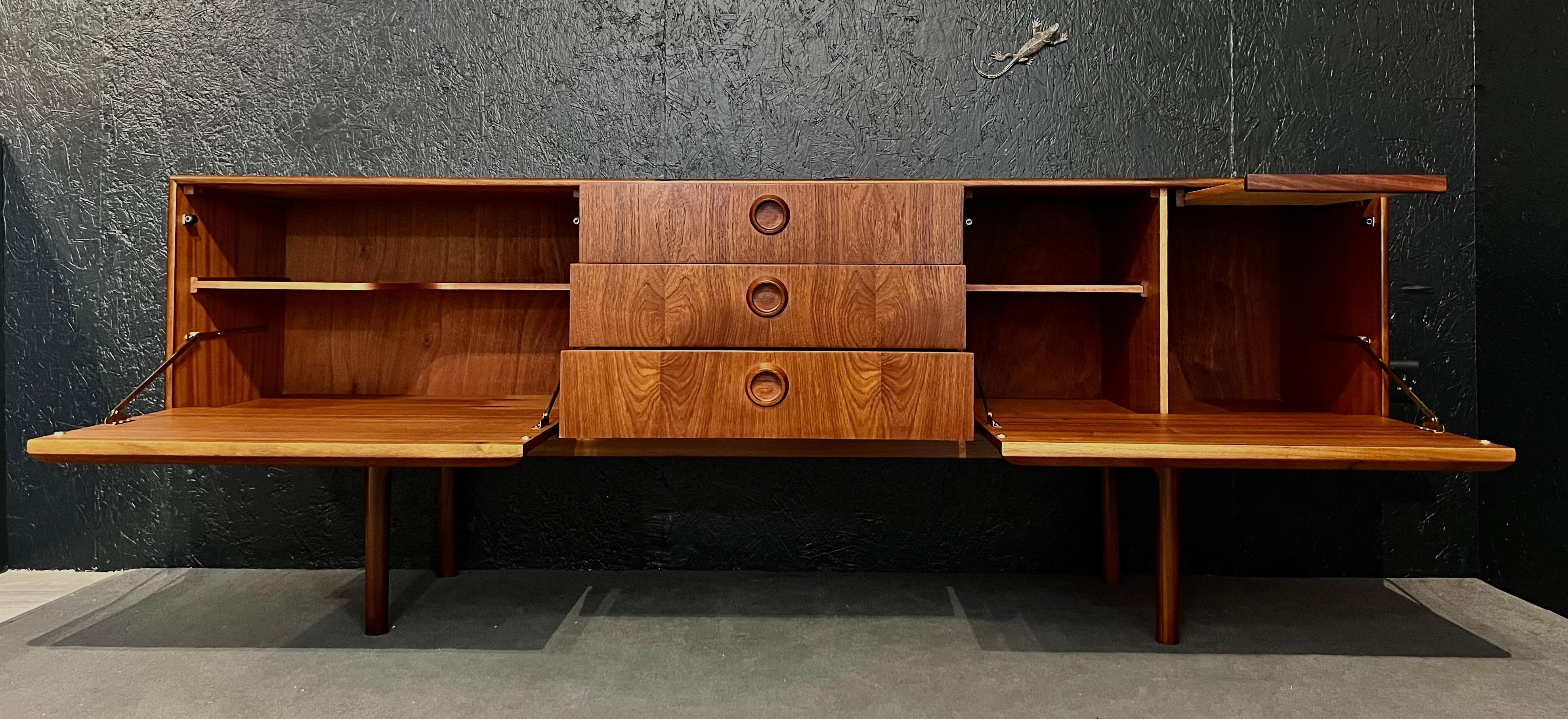 Stunning and unusual mid-century sideboard designed by Tom Robertson for cabinetmaker A.H. McIntosh in Scotland for the well-known Dunoon collection.

This piece is characterized by the artisan work, the beauty of its organic round handles and of