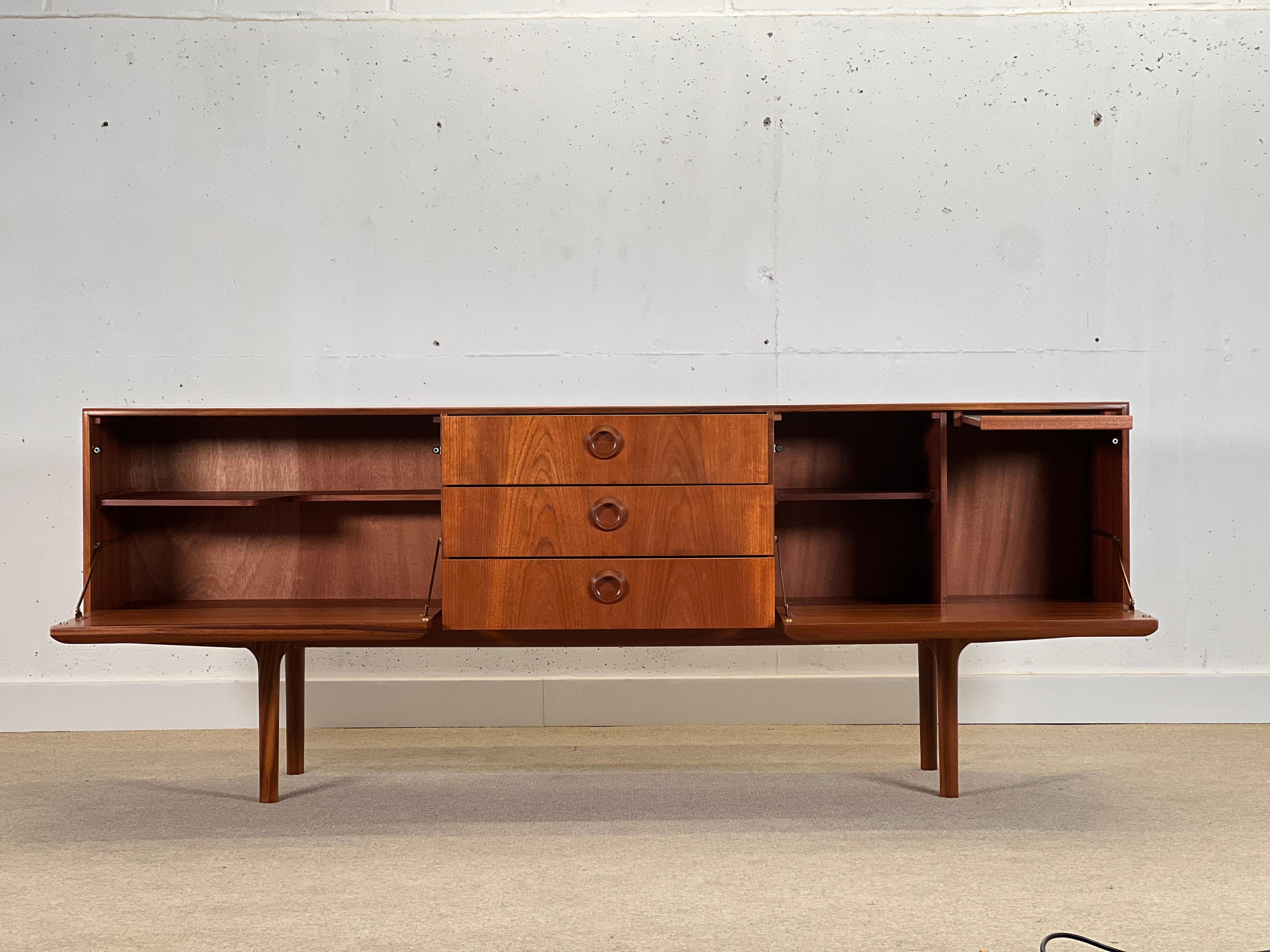 Stunning and unusual mid-century sideboard designed by Tom Robertson for cabinetmaker A.H. McIntosh in Scotland for the well-known Dunoon collection in the 1970s.

This piece is characterized by the artisan work, the beauty of its organic round