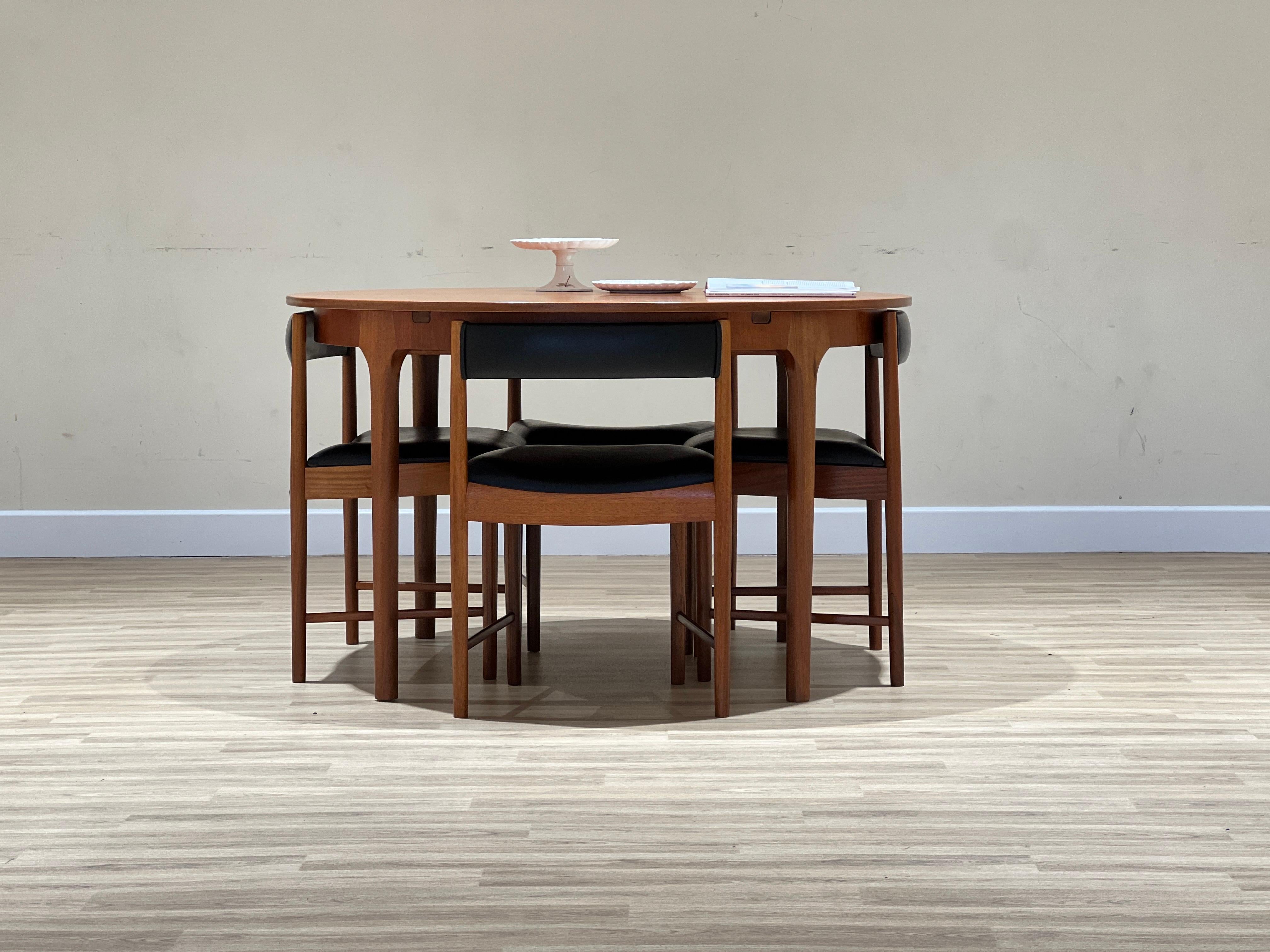 Set of an extendable circular table and 4 chairs from the Scottish firm A.H. McIntosh & Co., created by Tom Robertson.

This set was designed in the 70s. The table (model T21) is constructed with solid teak legs and teak veneered tabletop.

It opens