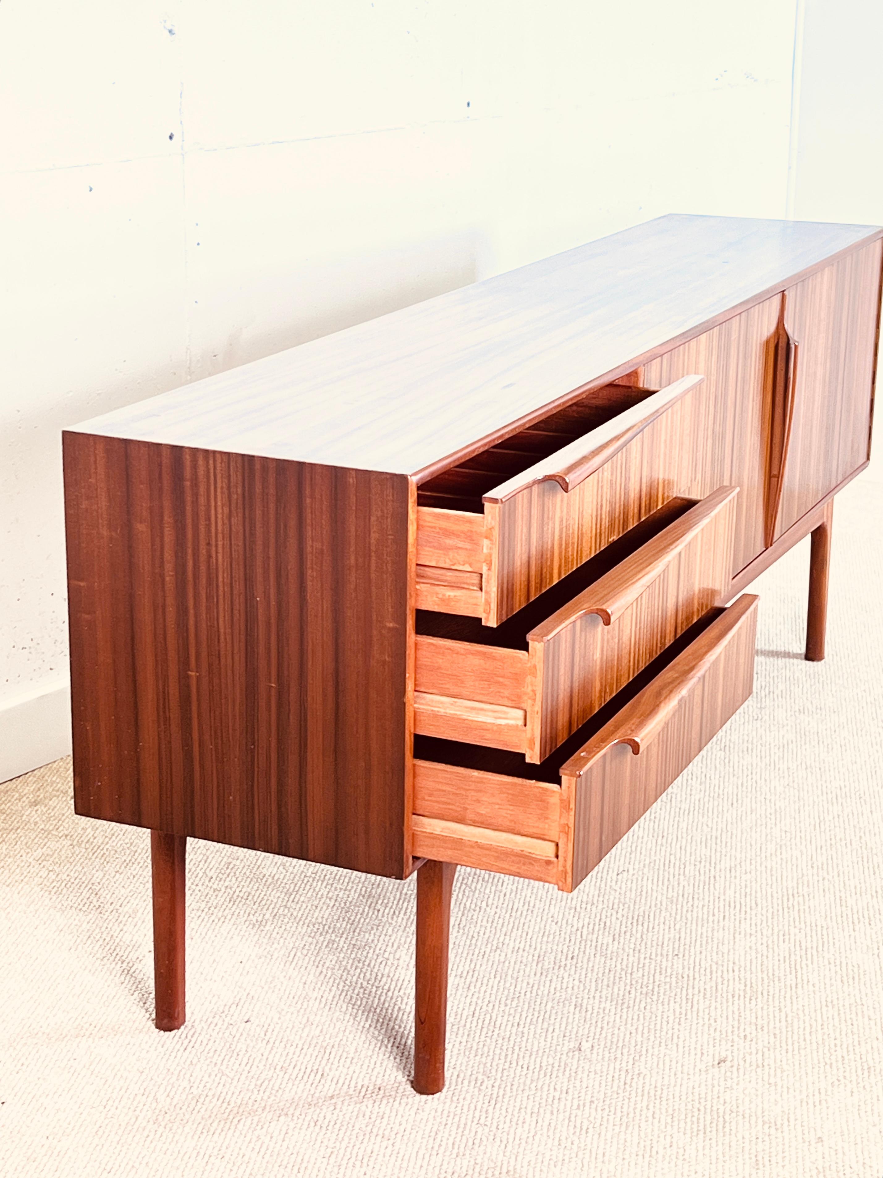 Tom Robertson designed this beautiful sideboard in Scotland in the early ‘70s for the well-known cabinet maker A.H. McIntosh.

The sideboard has two sections, one bank of three drawers, the top one lined up for the cutlery, and an, on its right, a