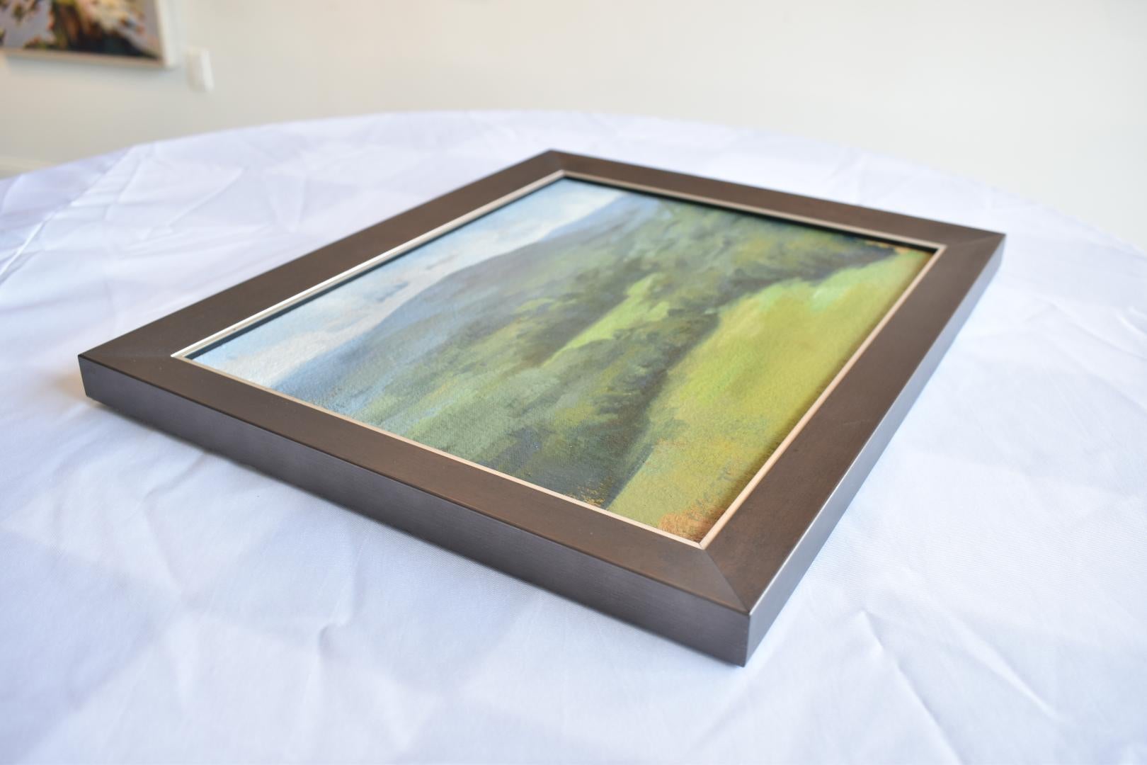This peaceful landscape called “High Sun” by McKenzie West captures the serene beauty of a verdant valley basking in the glow of midday light. Painted in rich, atmospheric layers, this oil on canvas depicts rolling hills stretching into the