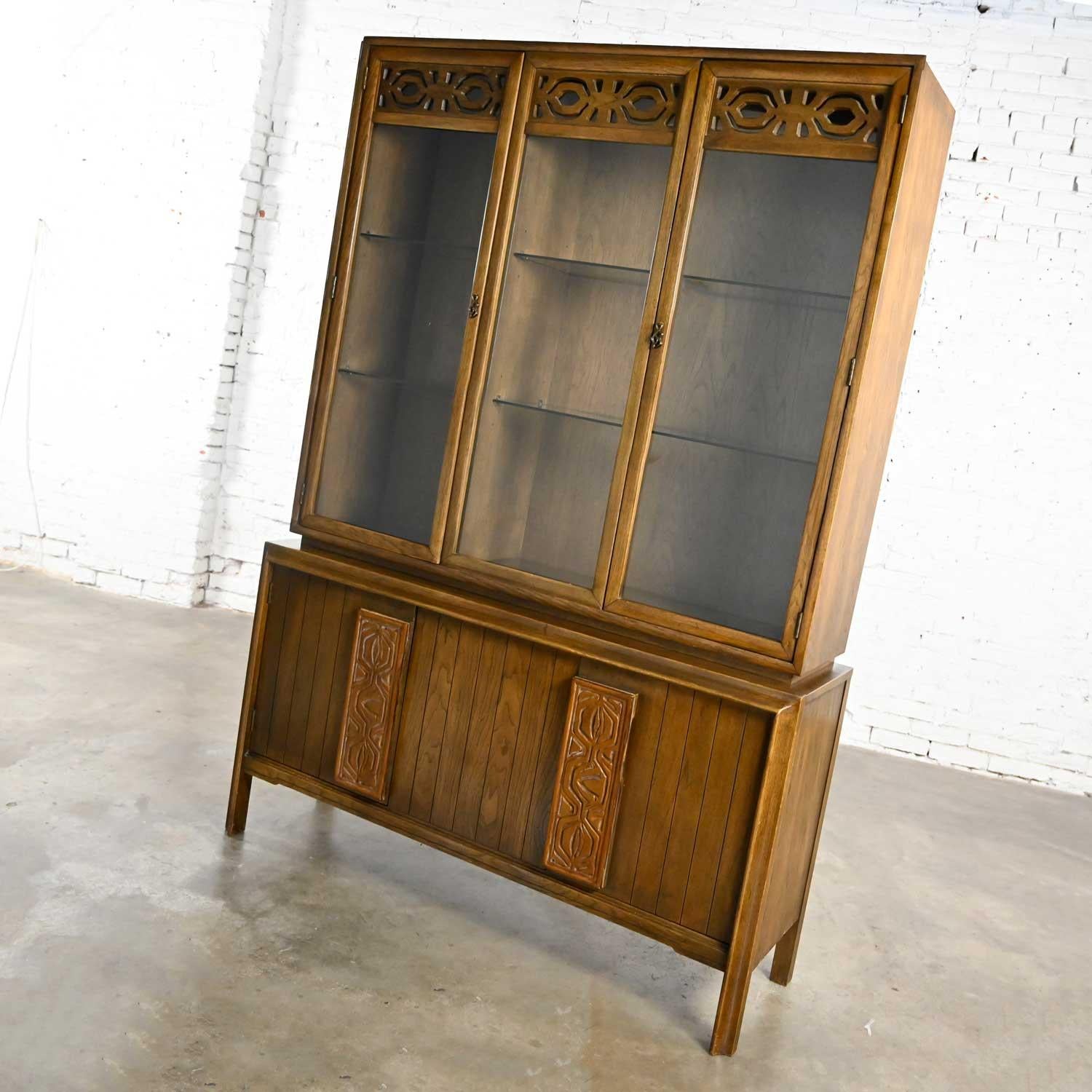 Lovely Mid-Century Modern one-piece Kroehler china cabinet or hutch with adjustable glass shelves, brass plated sculpted handles and hinges, lights, vertical carved door handles with waxed or whitewash finish, and horizontal carved designs on the
