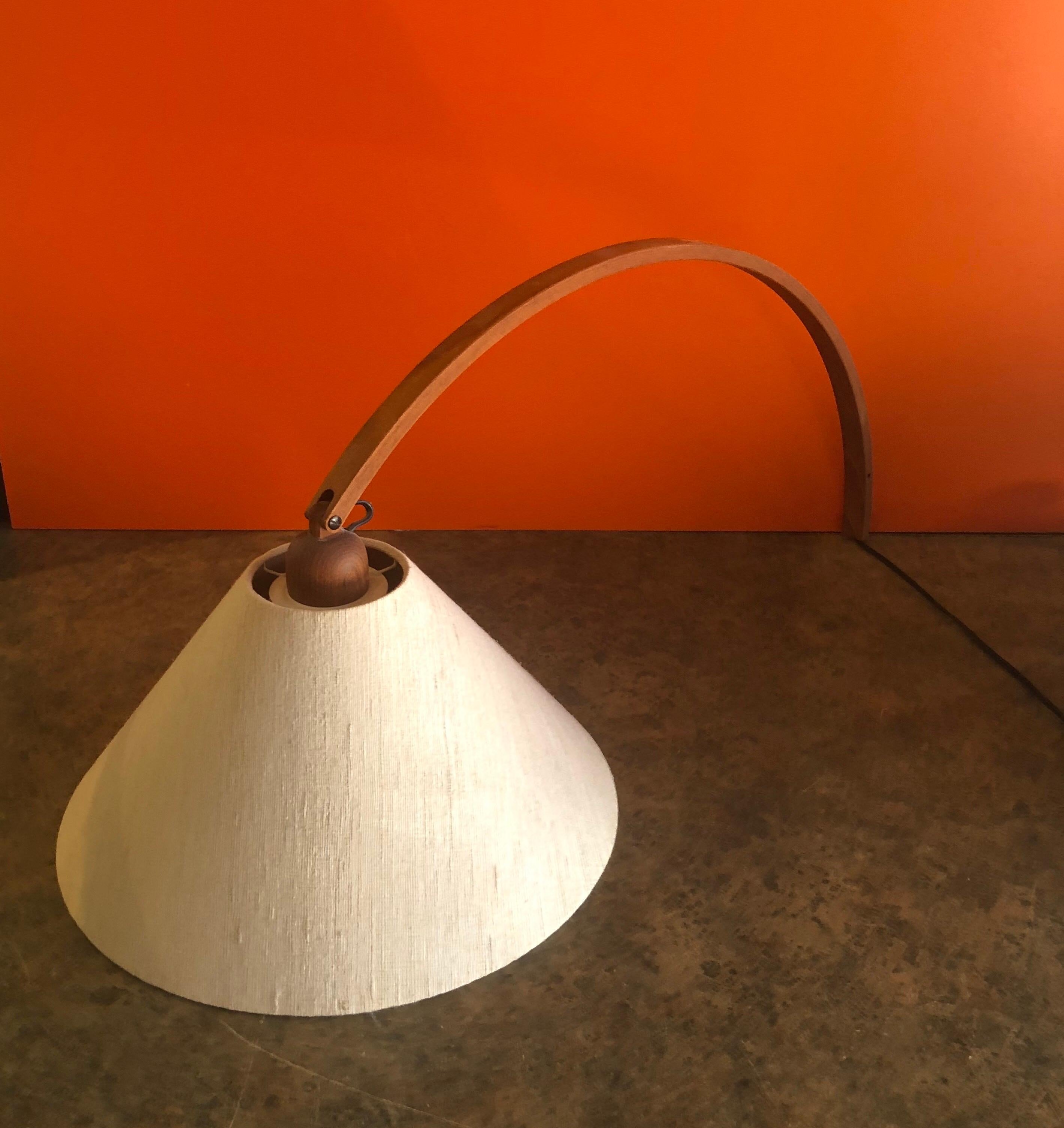 A very cool and rare MCM arched teak multi-Directional wall lamp or sconce, circa 1960s. The arched lamp can rotate 180 degrees left and right and move up and down on the 29