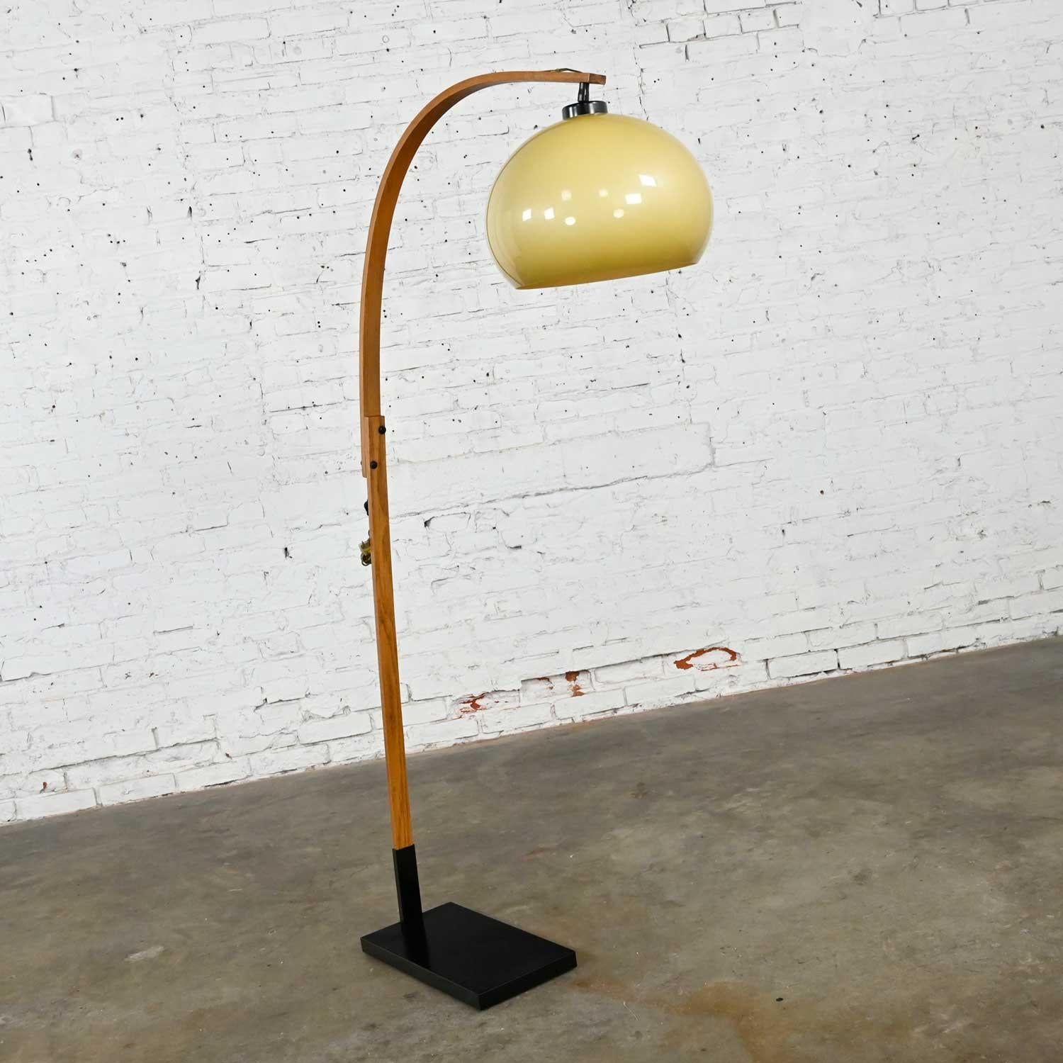 Gorgeous Mid-Century Modern bentwood swoop or arc floor lamp. Comprised of a bentwood stem, black painted iron base, and an adjustable amber plastic bubble globe shade. Beautiful condition, keeping in mind that this is vintage and not new so will