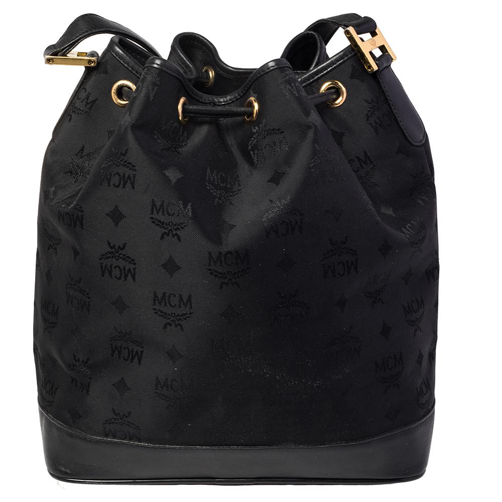 A much-loved bag style, the bucket bag is a closet staple. The MCM design exhibits a display of minimal details. This bag is crafted from signature canvas as well as leather and it has a top handle, shoulder strap, drawstring closure, and a fabric