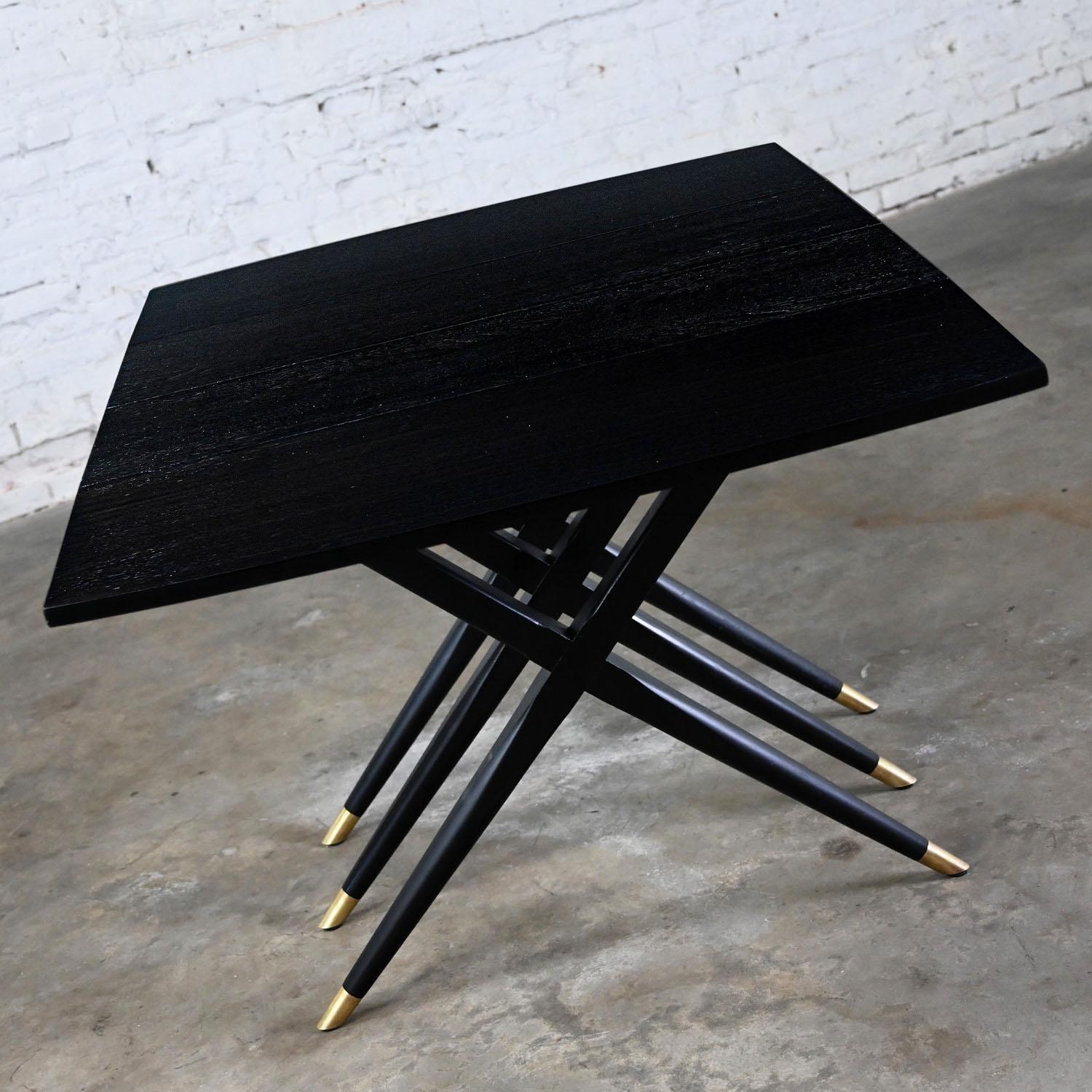 Handsome vintage MCM (Mid-Century Modern) with an Art Deco flair black dyed dining table with drop leaf feature & triple scissor leg base with brass sabots, by Craddock Furniture. Beautiful condition, keeping in mind that this is vintage and not new