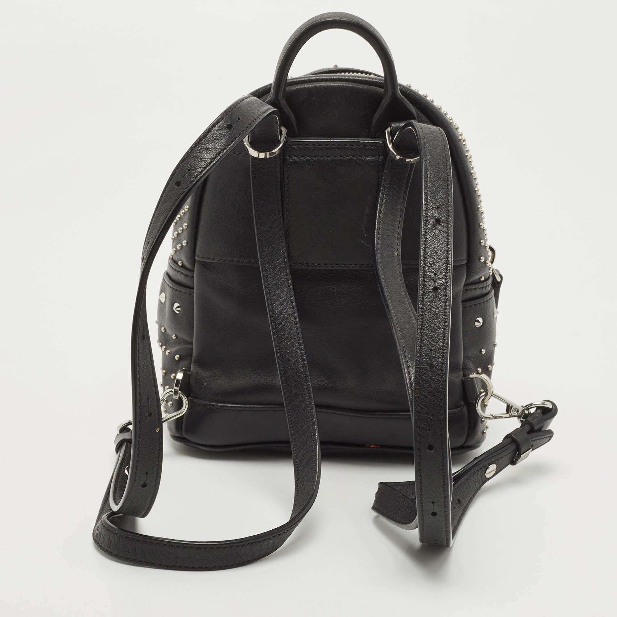 This MCM Stark-Bebe Boo backpack will come in handy for daily use or as a style statement. It is crafted from black leather and designed with silver-tone studs. It features a front zip pocket and a slip pocket on the sides.

