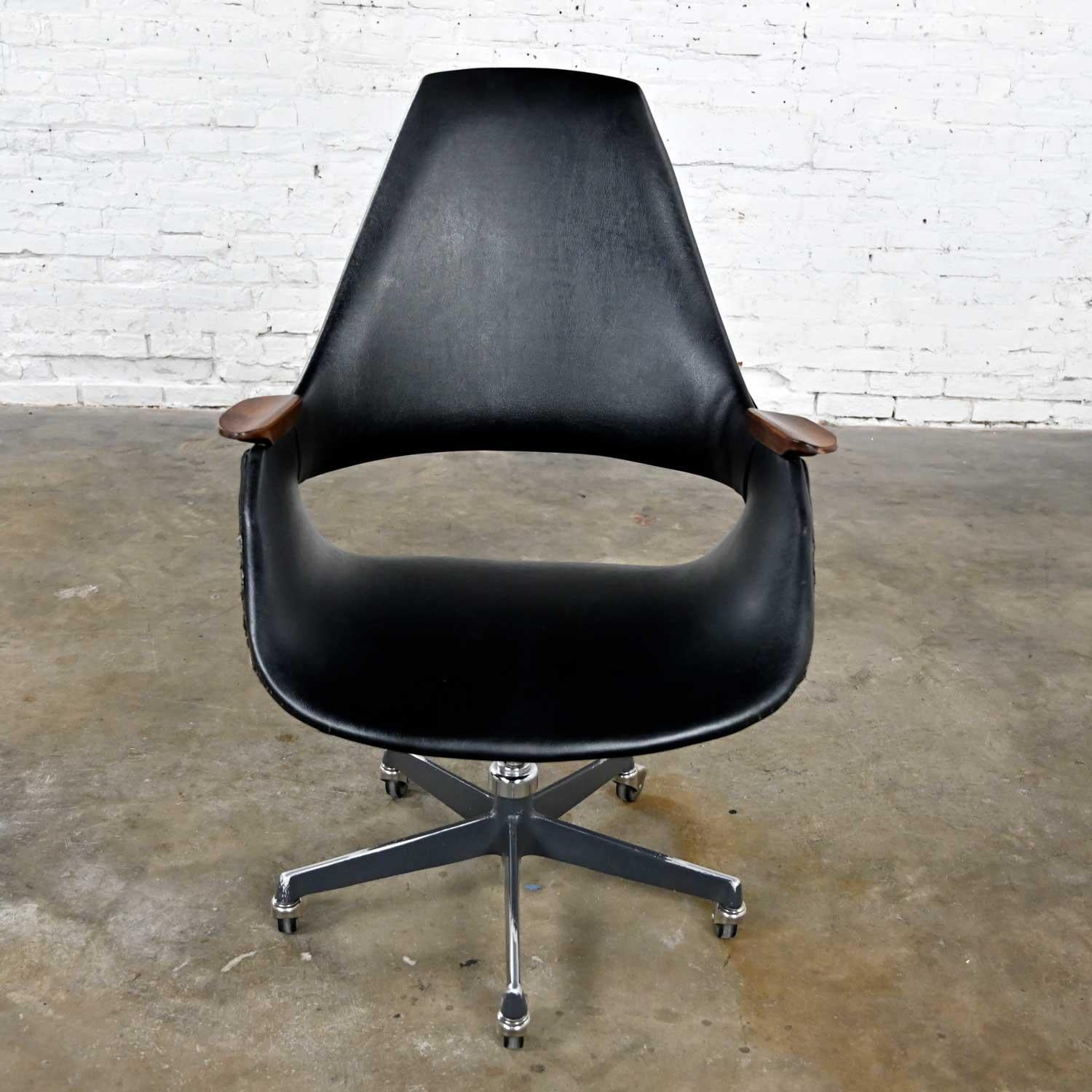 Awesome vintage Mid-Century Modern Space Age black vinyl desk armchair no. 2635 with wood arms and a five-prong cast aluminum base with casters by Arthur Umanoff for Madison Furniture. Beautiful condition, keeping in mind that this is vintage and