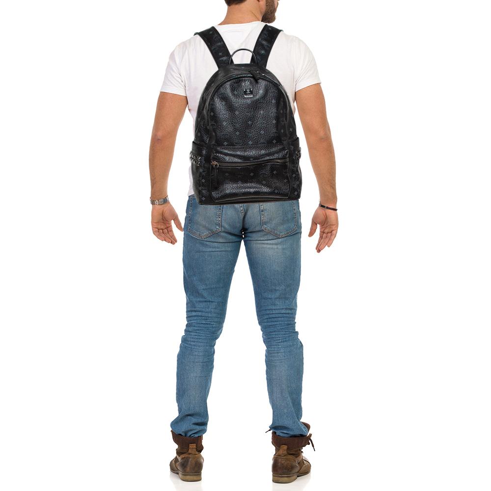 This stunning MCM backpack will come in handy for daily use or as a style statement. It is crafted from signature coated canvas and designed with a front pocket and a spacious interior secured by a zipper. Two shoulder straps and a small top handle