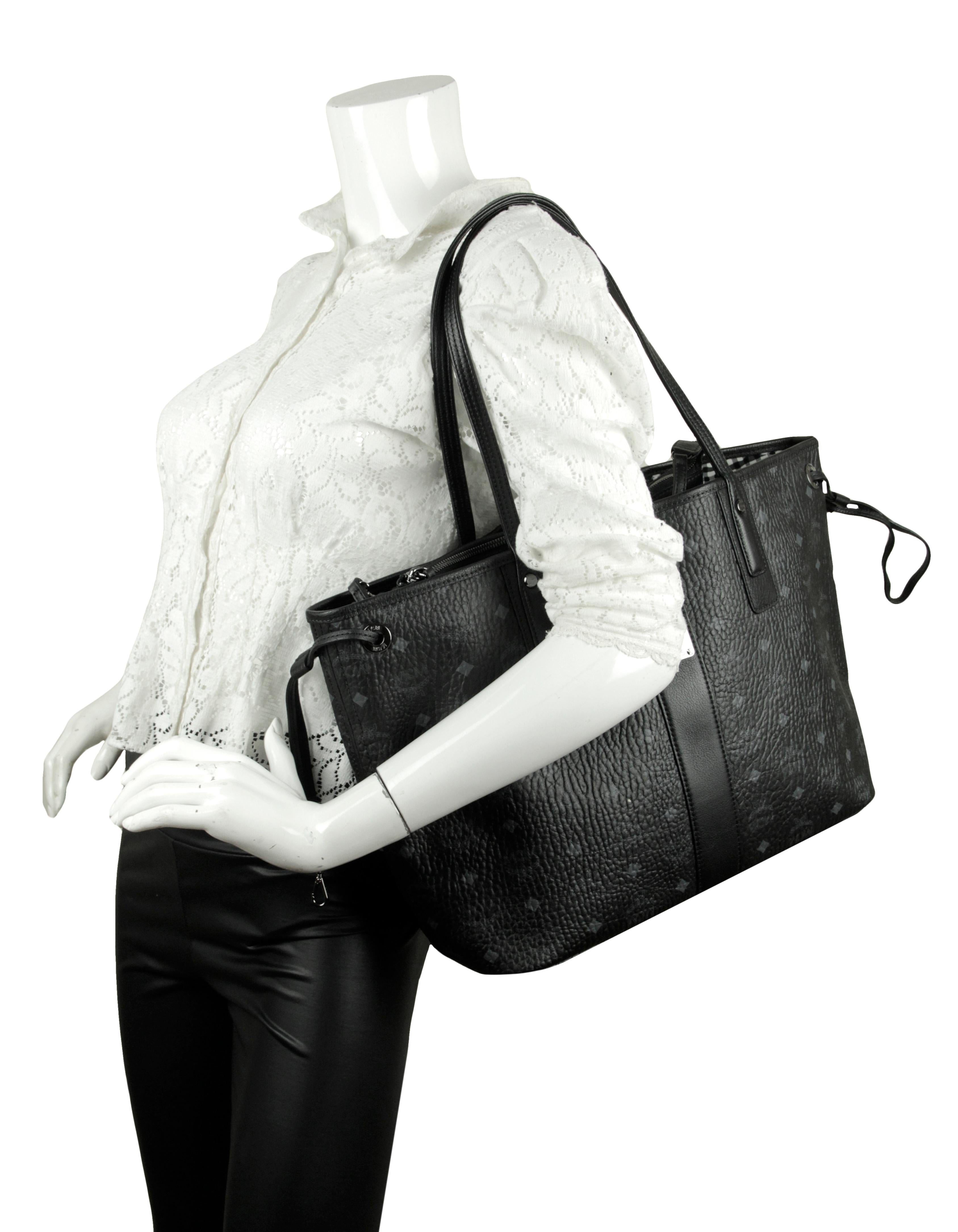 MCM Black Visetos Large Liz Reversible Shopper Tote Bag.  
Made In: Korea
Color: Black, white and grey
Hardware: Darkened silvertone
Materials: Coated canvas with leather handles and canvas reversible interior
Closure/Opening: Open top
Exterior
