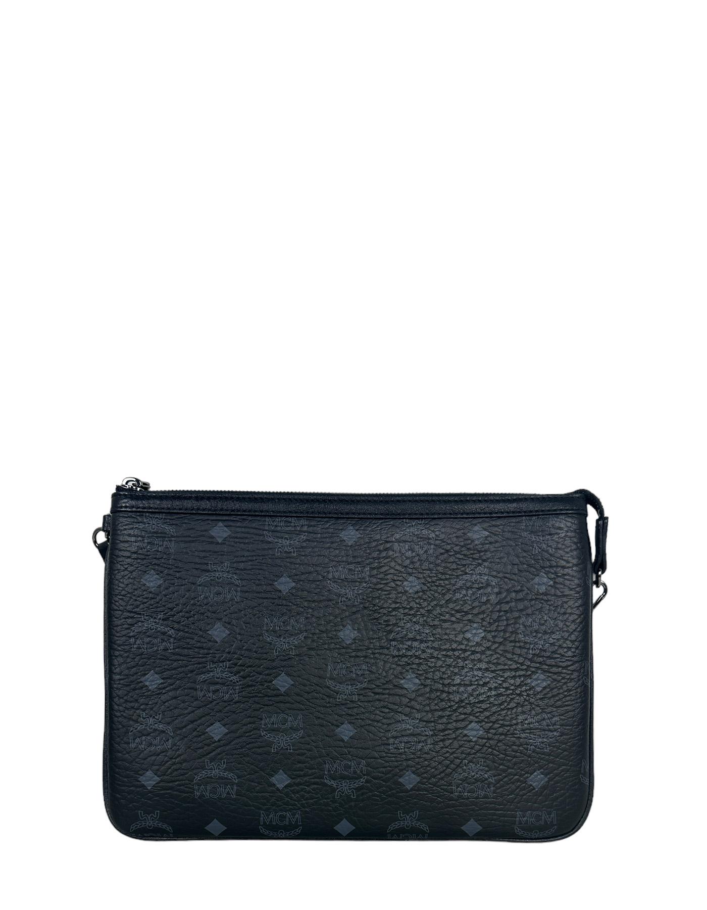 MCM Black Visetos Monogram Pouch Bag. Strap can be moved to also be used as a wristlet
Made In: Korea
Color: Black
Hardware: Darkened silvertone
Materials: Coated canvas
Lining: Fine textile
Closure/Opening: Zip top 
Exterior Pockets: N/a
Interior