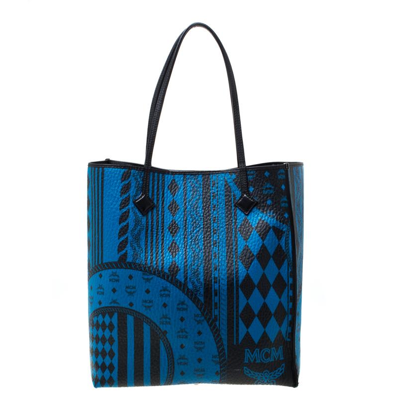 Featuring a smart and stylish appearance, this MCM tote is distinctive and very modern. Crafted from leather, the black/blue tote features dual handles and a baroque print on the exterior. It opens to a spacious fabric-lined interior and you will