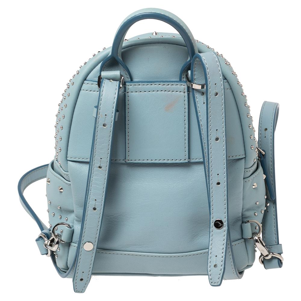 This MCM Strak-Bebe Boo backpack will come in handy for daily use or as a style statement. It is crafted from blue leather and designed with gold-tone studs all over in varied sizes. It features a front zip pocket and two slip pockets on the sides.