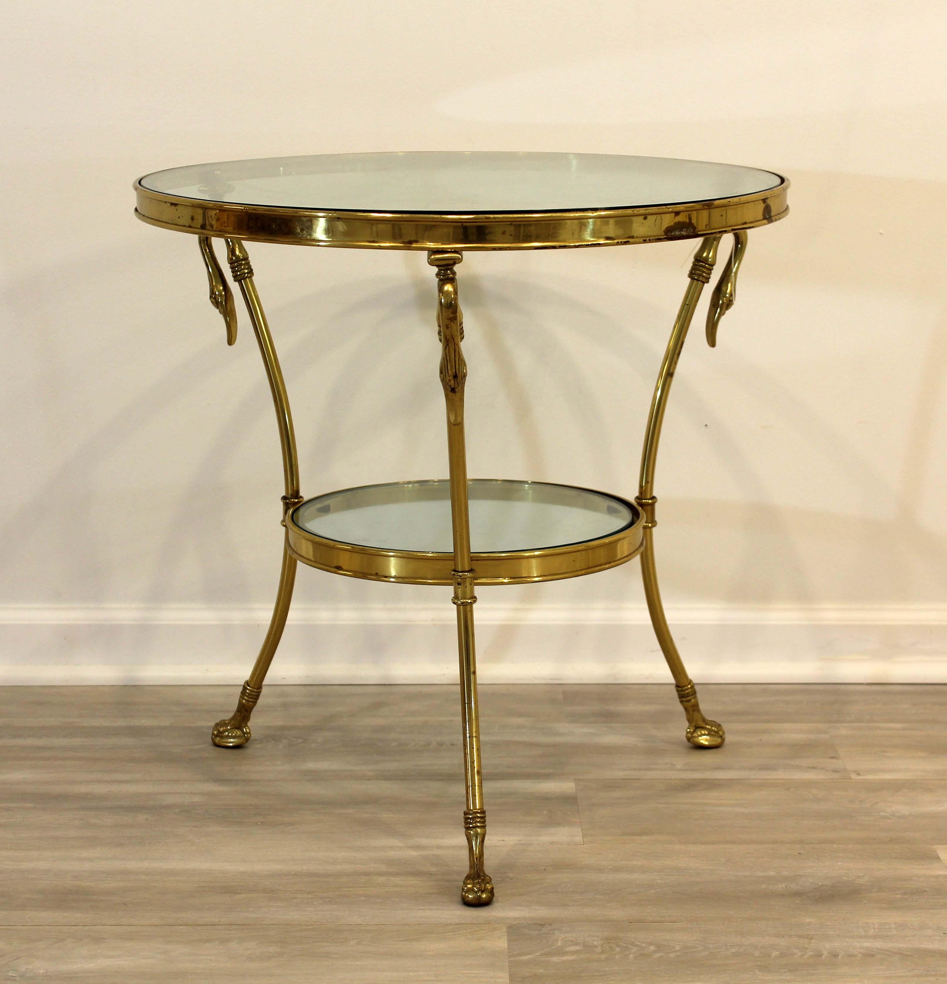 This vintage brass, tri-legged side or occasional table from Maison Jansen is detailed with goose/duck heads with corresponding feet while two tiers of glass offer extra storage display space.

This piece is in good condition with some pitting and