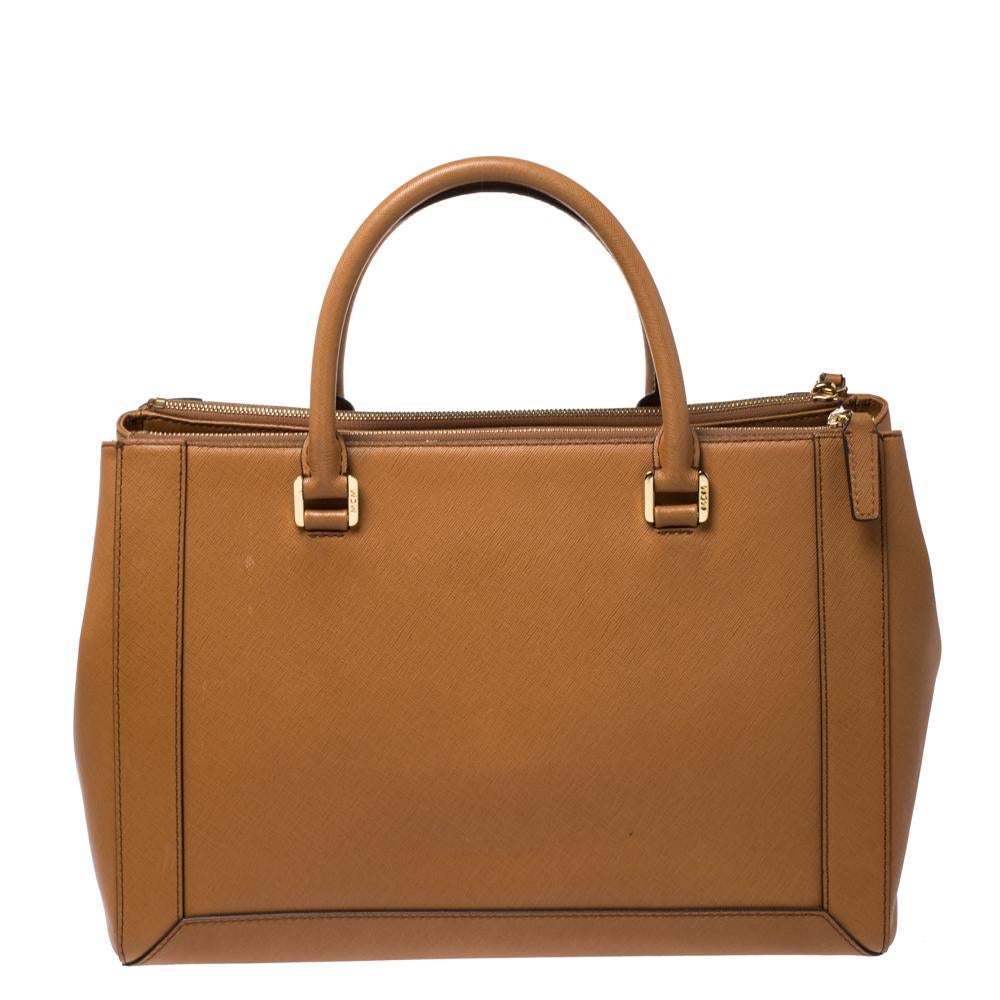 Crafted from the finest leather, this MCM bag is sure to enhance your ensemble. The neat brown bag is lined with fabric and features dual handles and a shoulder strap. Keep your essentials safe in this Nuovo tote.

Includes:Info Booklet, Detachable