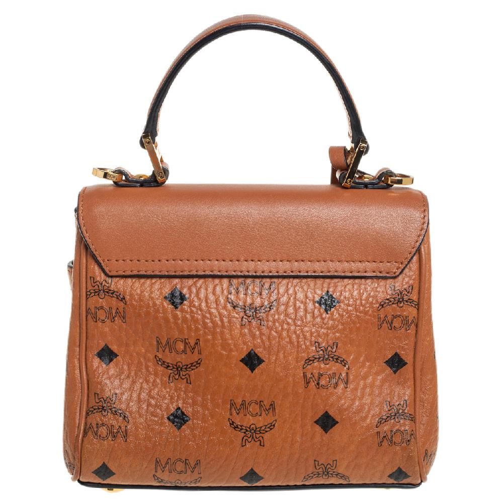 This stunning Mini Heritage bag in Visetos canvas and leather is from MCM's prized collection of handbags. It features a single top handle, a twist-lock closure on the front flap, and a fabric-lined interior. It is detailed with gold-tone hardware