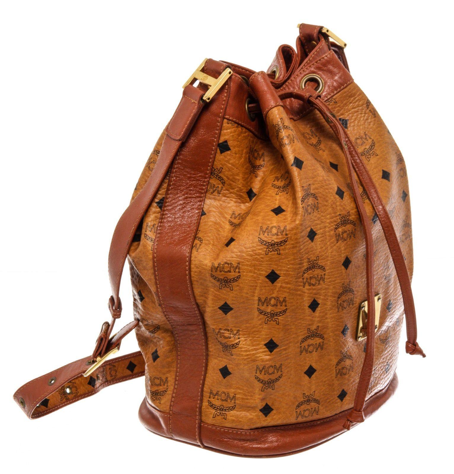 MCM Brown Visetos Coated Canvas Leather Bucket Bag with gold-tone hardware, trim visetos coated canvas leather, shoulder strap and drawstring closure.

62797MSC