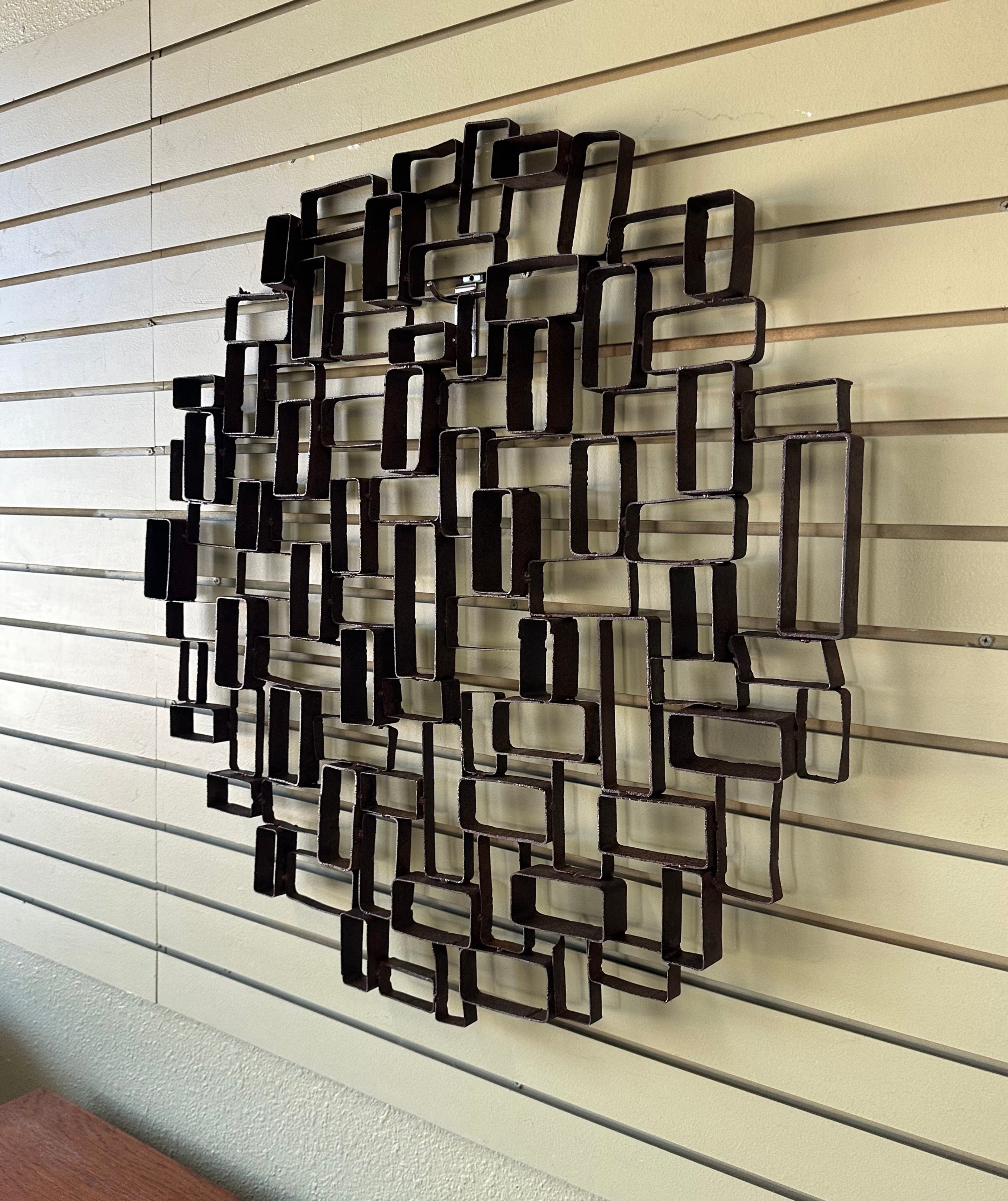 Striking MCM Brutalist geometric distressed steel wall sculpture, circa 1970s. The piece is in distressed vintage condition and measures 32.5