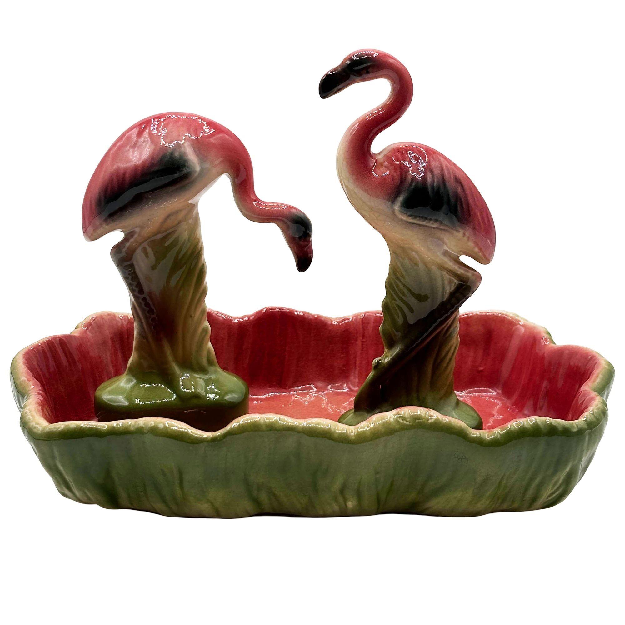 Mid-Century-Satz von 2 rosa und grünen Flamingo Keramik-Figuren mit Flamingo Pool Tablett dekorative Schale. Das Set besteht aus zwei wunderschön detaillierten rosa Flamingos mit ausgebreiteten Flügeln inmitten üppiger grüner Blätter und einem