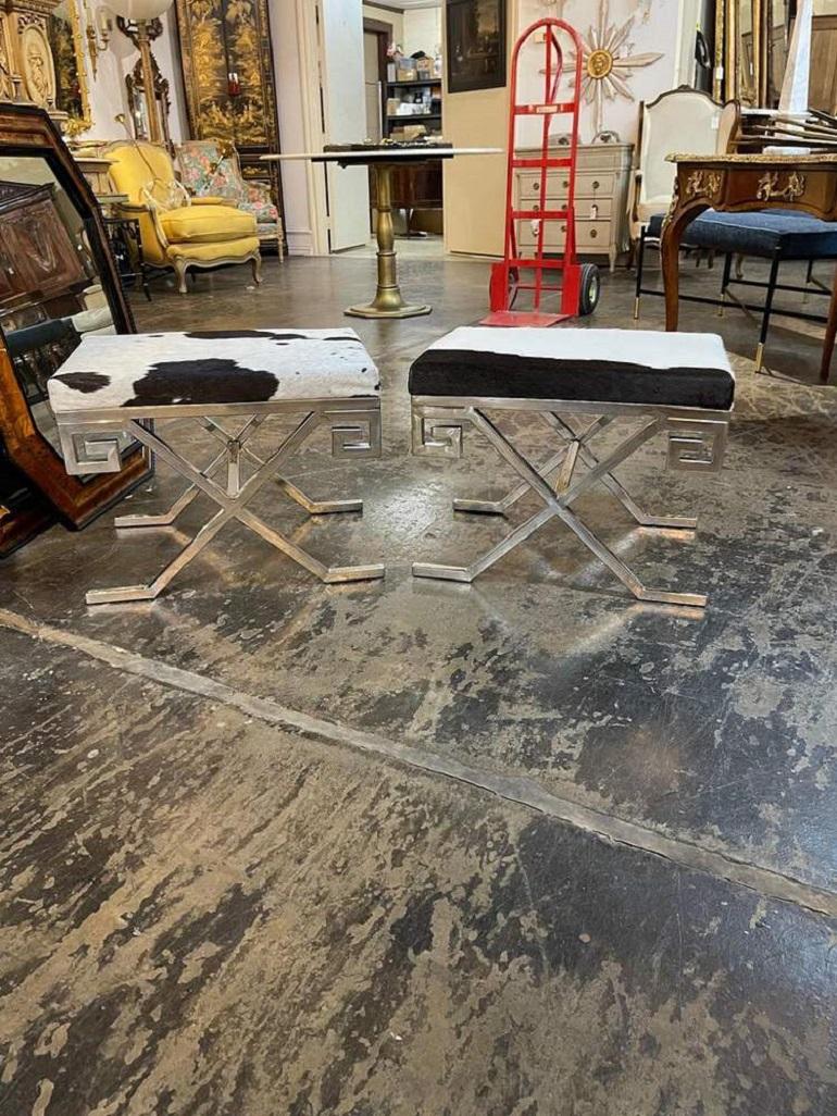 Interesting chrome MCM stools with cowhide upholstery. Styled after the French designer Jean Michel Frank. Very fine quality and sure to put a smile on your face! Note price listed is for one item. There are 2 available.